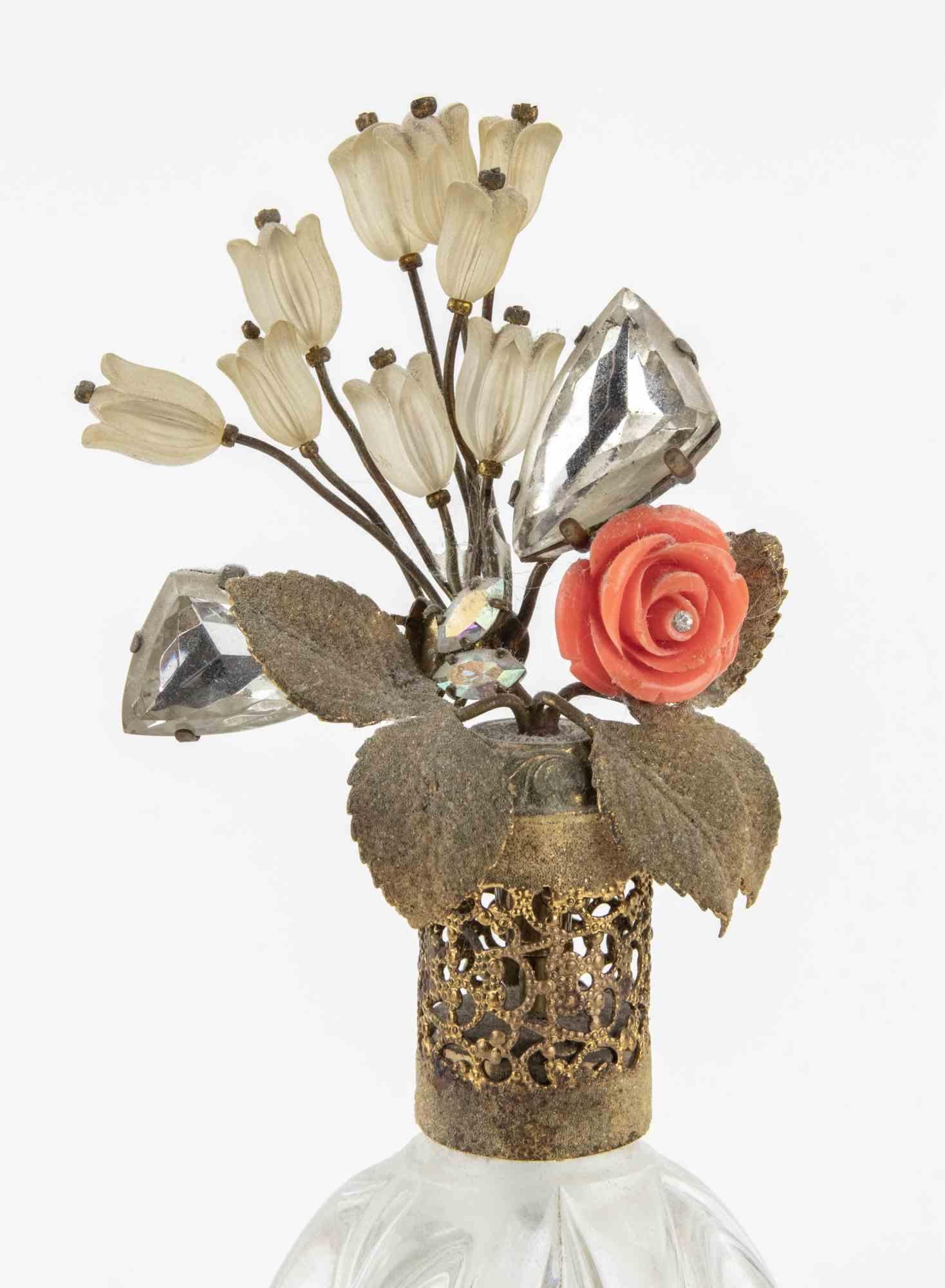 Price Clear Glass Perfume Bottle with Jeweled Top made in France between 1930s and 1940s.

Gilded Metal and crystal decorations.

Good condition.