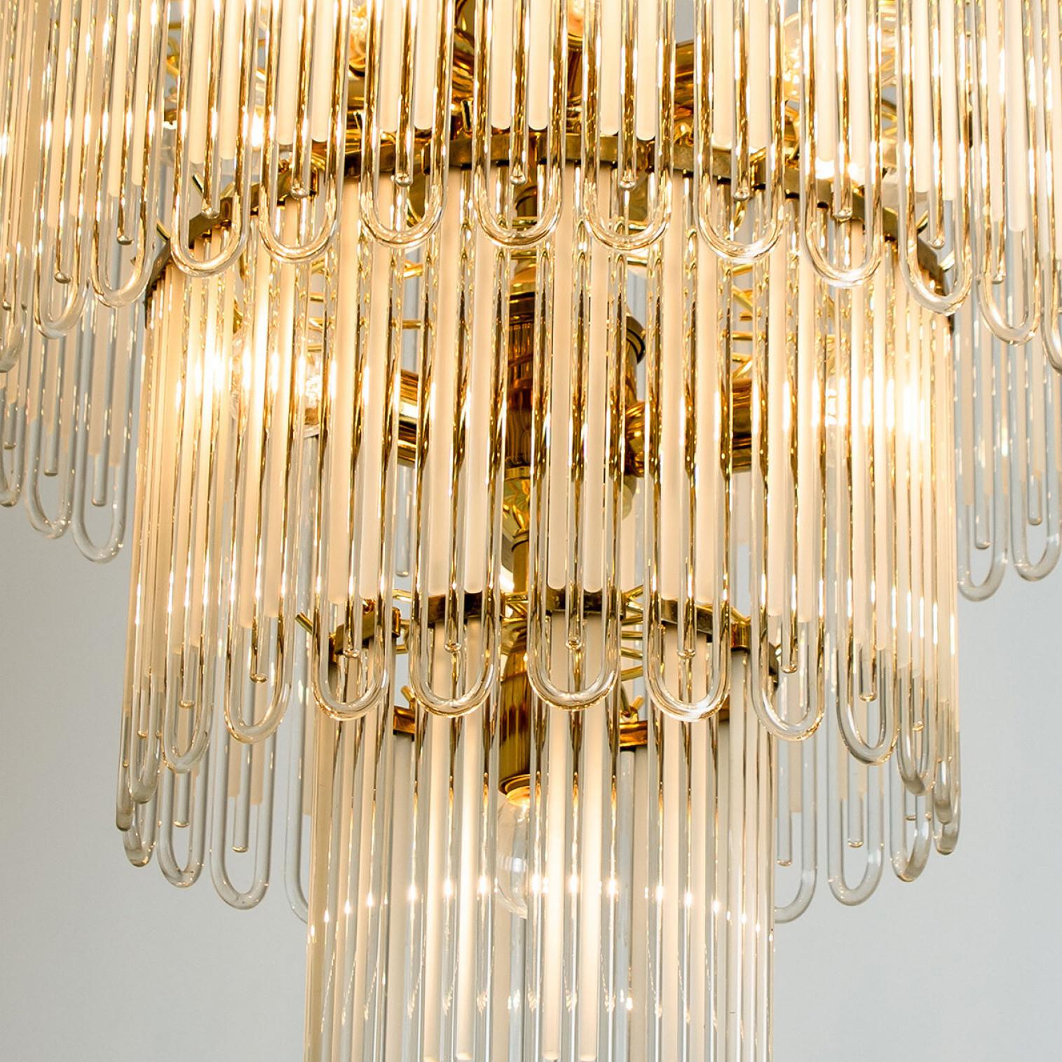 Clean lines to complement all decors. Wonderful high-end light fixture by Sciolari. With brass detail hanging glass giving the piece an elegant appearance which refracts the light, filling a room with a soft, warm glow

The chandelier has brass