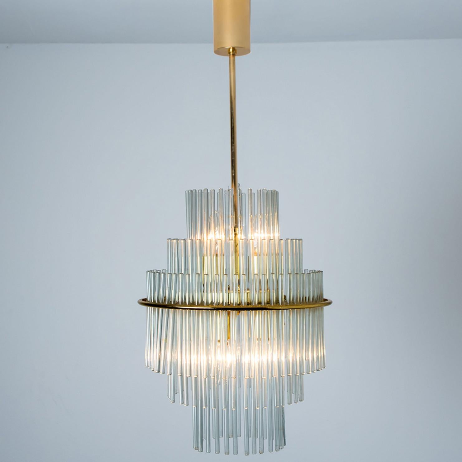 Clean lines to complement all decors. Wonderful high-end light fixture by Sciolari. With brass detail hanging glass giving the piece an elegant appearance which refracts the light, filling a room with a soft, warm glow.

The chandelier has brass