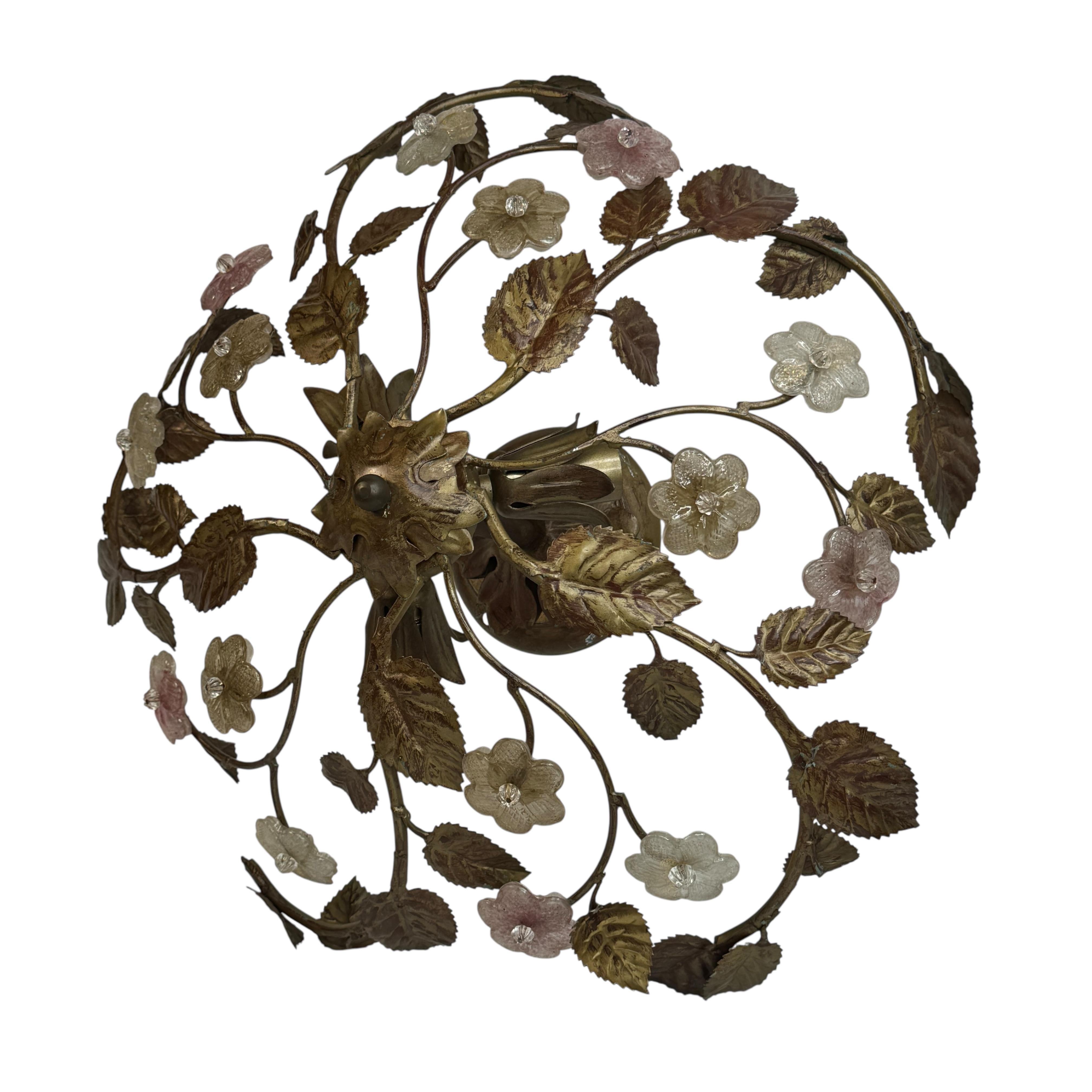 Aggiungi un tocco di opulenza alla tua casa con questo charme da incasso. Perfette foglie in metallo dorato con fiori in vetro di Murano fatti a mano per valorizzare qualsiasi casa chic o eclettica. Ci piacerebbe vederlo appeso all'ingresso come