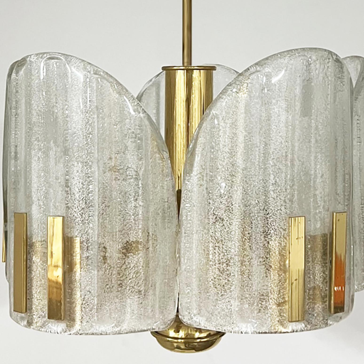 Charming chandelier in the style of Fagerlund, Sweden. From around 1960. Consists of five crystal handmade glass cylinders on polished brass arms.

The texture of the glass gives the illusion of ice crystals which creates a beautiful ambience.