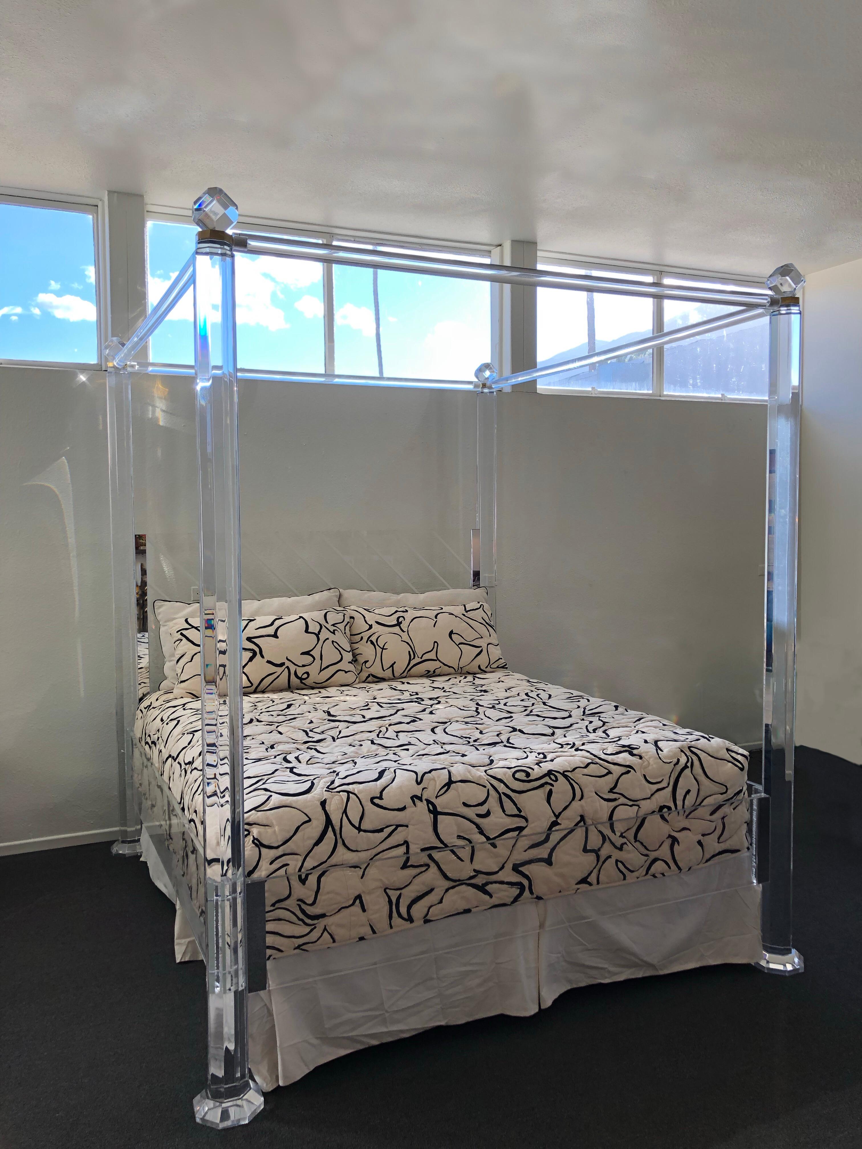 A glamorous 1980s clear Lucite and brass canopy bed in the manner of Charles Hollis Jones. The headboard lights up for mood light. The bed frame has been newly professionally polished. The price is for Lucite bed frame and mattress. The bedspread is