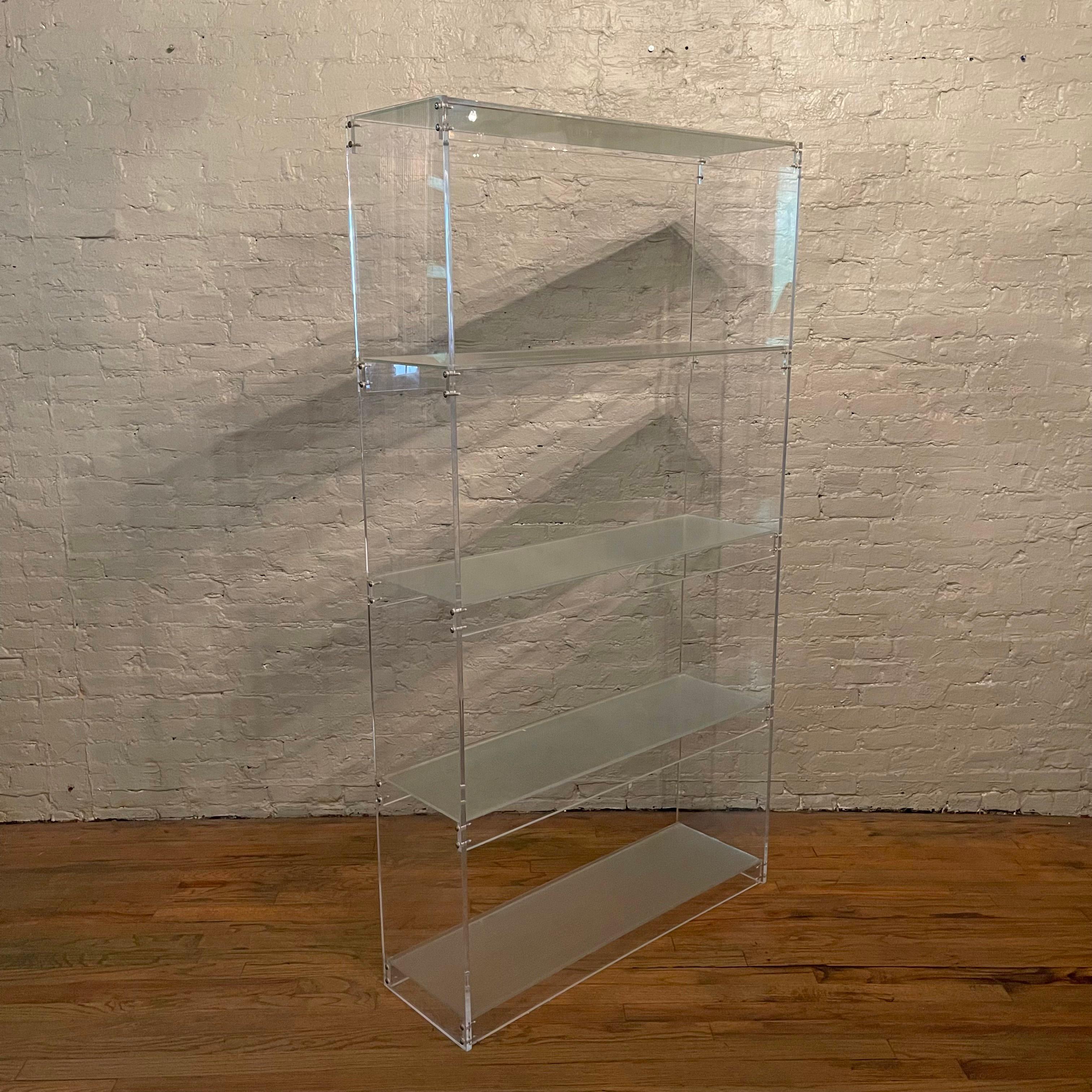 Clear Lucite, etagere, open shelving unit with architectural glass shelves features four sections divided evenly at 16 inches height. There is a complimentary contrast between the clear Lucite frame and textured glass that elevates this piece. This
