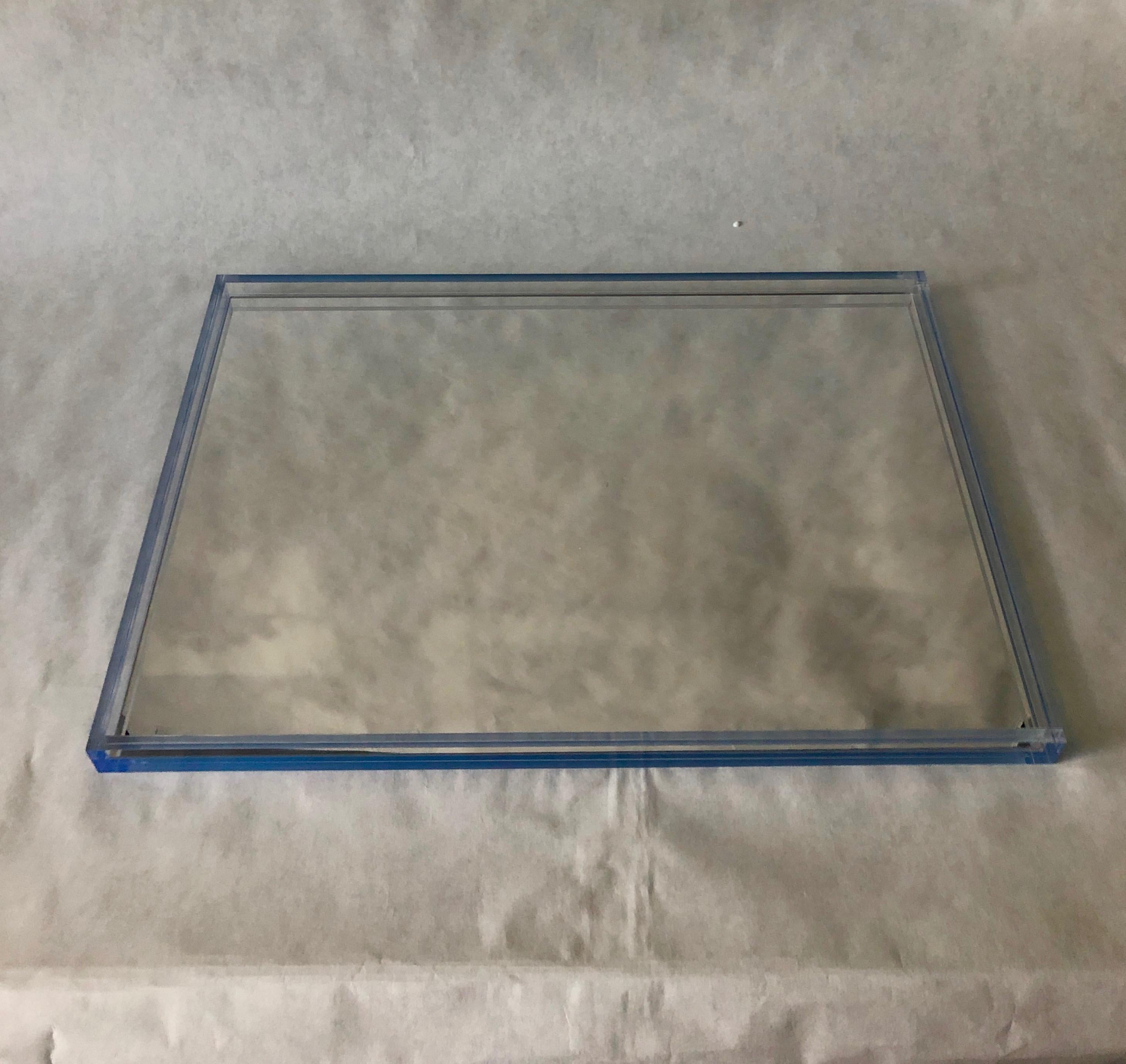 Offered is an early signed Tinsley Mortimer clear Lucite with Imbedded blue border and mirrored base Minimalist decorative barware / drinks / serving tray. The Lucite used in this design is substantial and quite exceptional. The blue accents to this