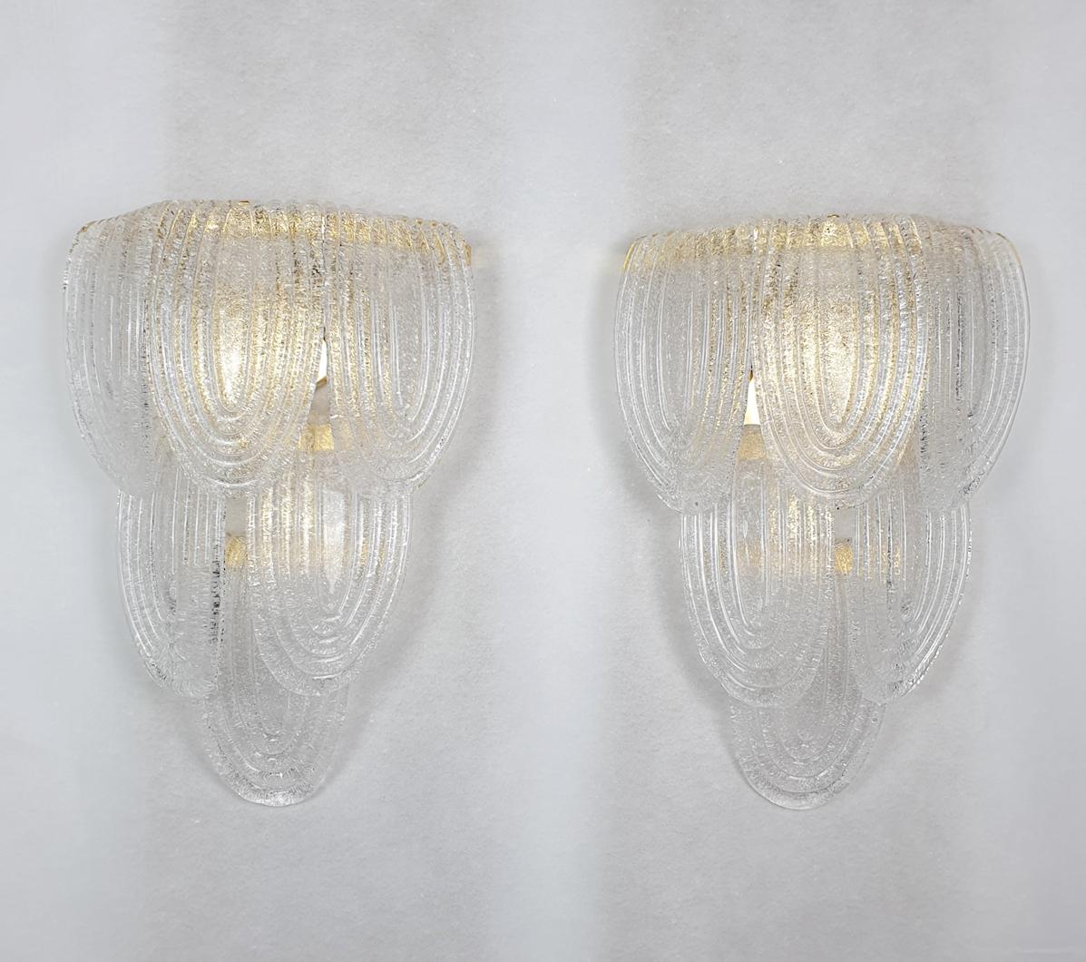 Pair of Mid-Century Modern Murano glass wall sconces, by Mazzega, Italy, 1970s.
The vintage pair of sconces is made of clear & textured Murano glass and gold plated frame.
Matching chandelier available.
Each sconces has 3 lights, and is rewired for