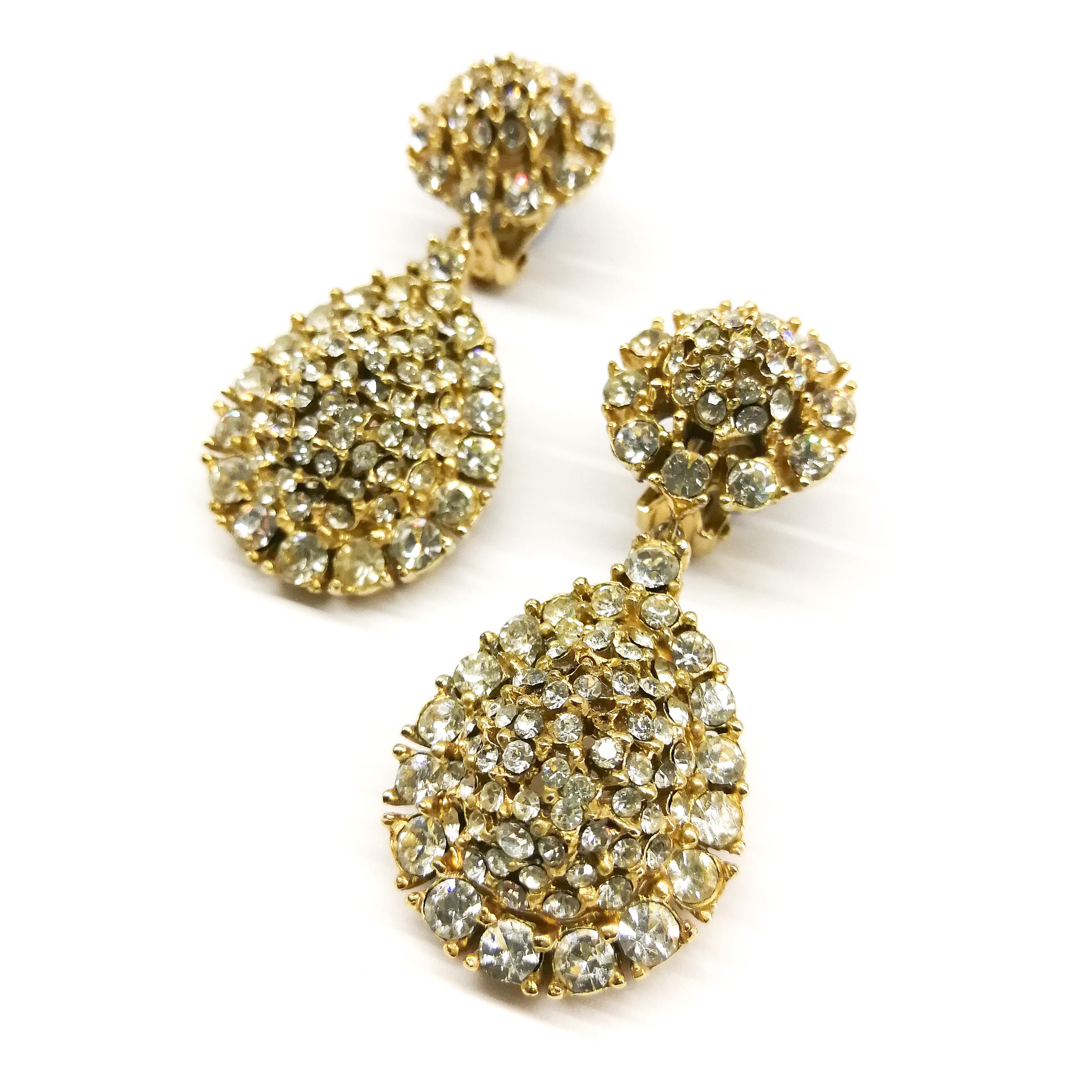 These charming clear paste drops sparkle away, a simple drop suspended from a stylised floral top. Made to the highest quality as is expected from Ciner, they are a classic earrings, perfect for a wedding or less formal outing.
The Ciner