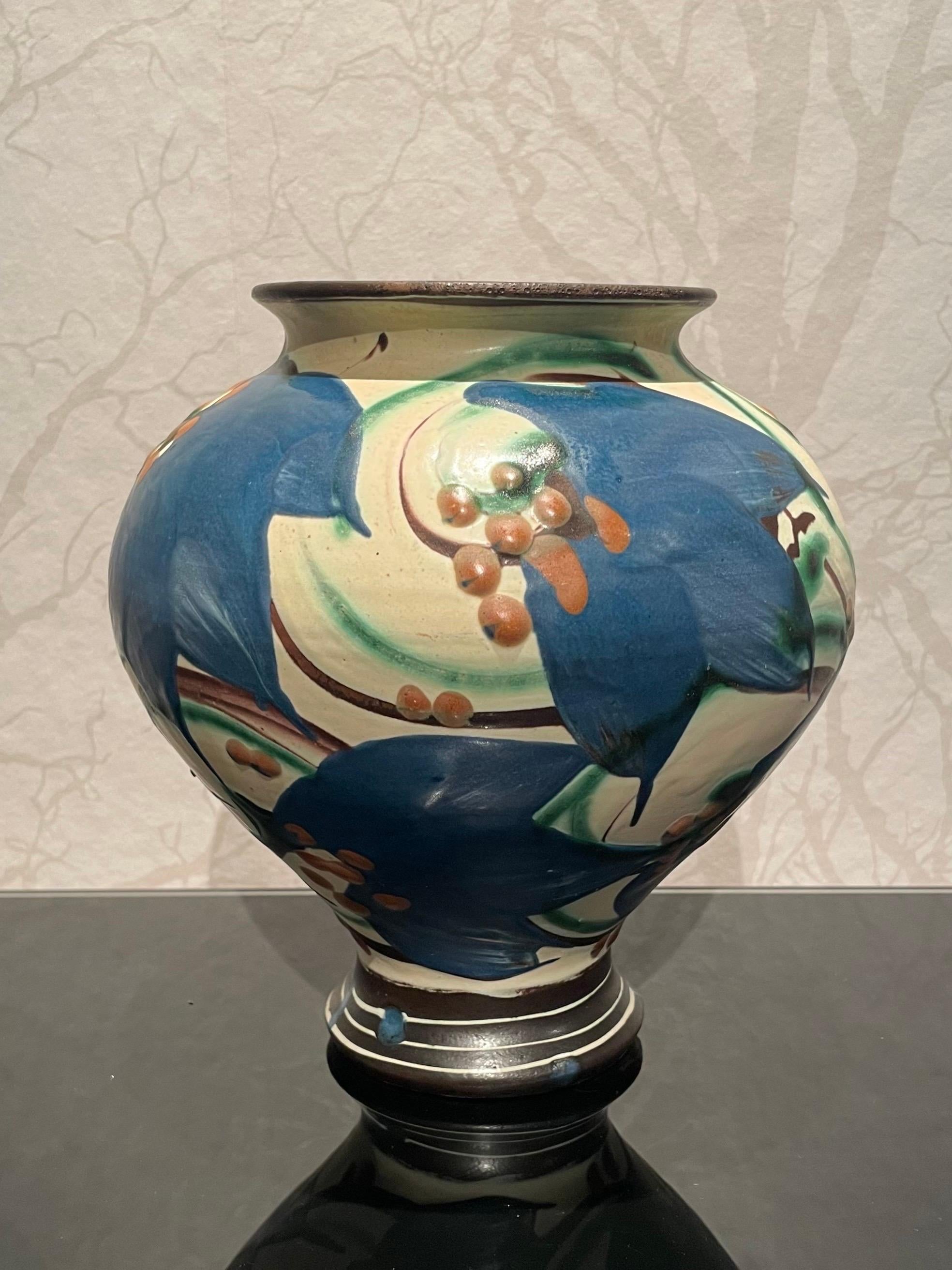 This is the 1920s Danish 20 cm high ceramic vase by Herman Kähler.

It comes with a baluster shaped body. It has a matte surface with parts of glossiness. A beautiful cow horn glazed pattern with light blue climbing Clematis flowers on a beige