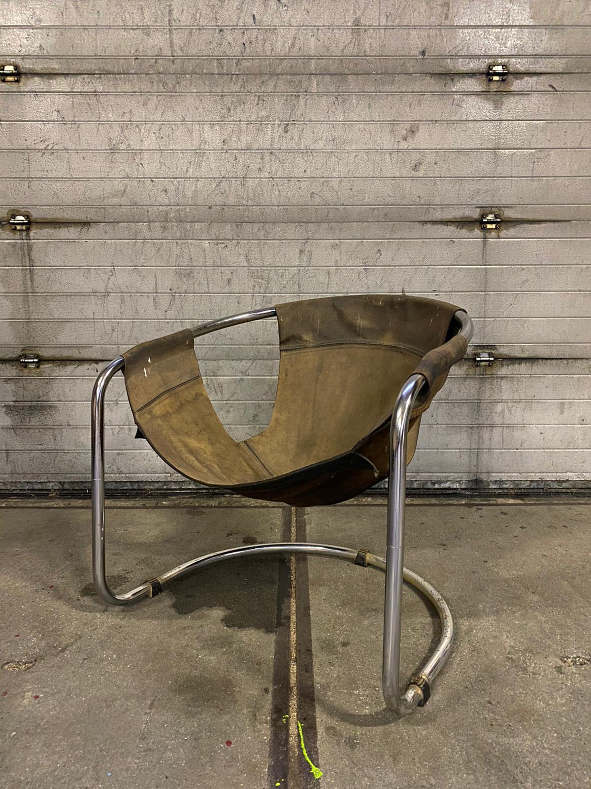 Dutch design armchair designed by Clemens Claessen for Ba-As Eindhoven, NL. The chair features a chrome tubular base which consists of two parts. It’s seating was made from thick saddle leather which shows some heavy wear as overall stains, some