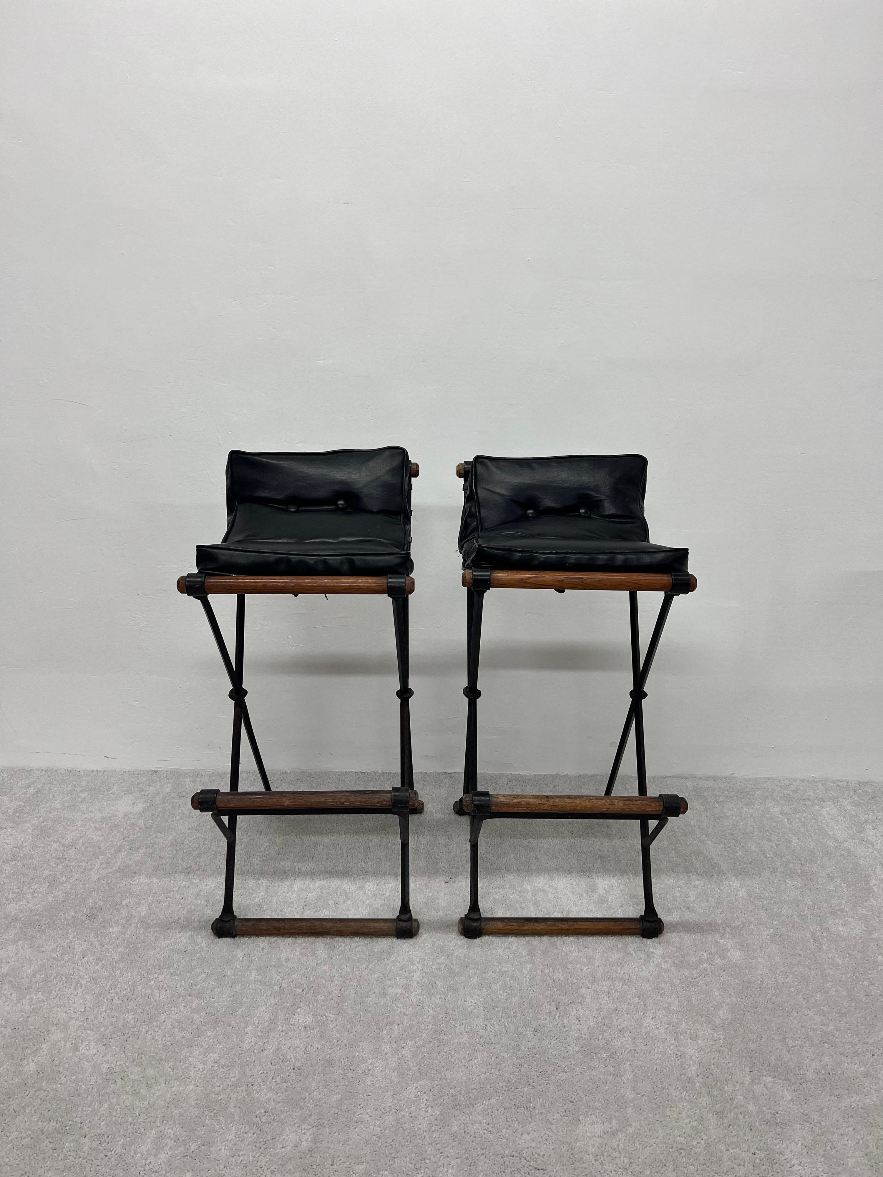 Mid-Century Modern wrought iron barstools with original eco-leather black seat cushions and wood foot rests by Cleo Baldon for Terra Furniture, 1970s.