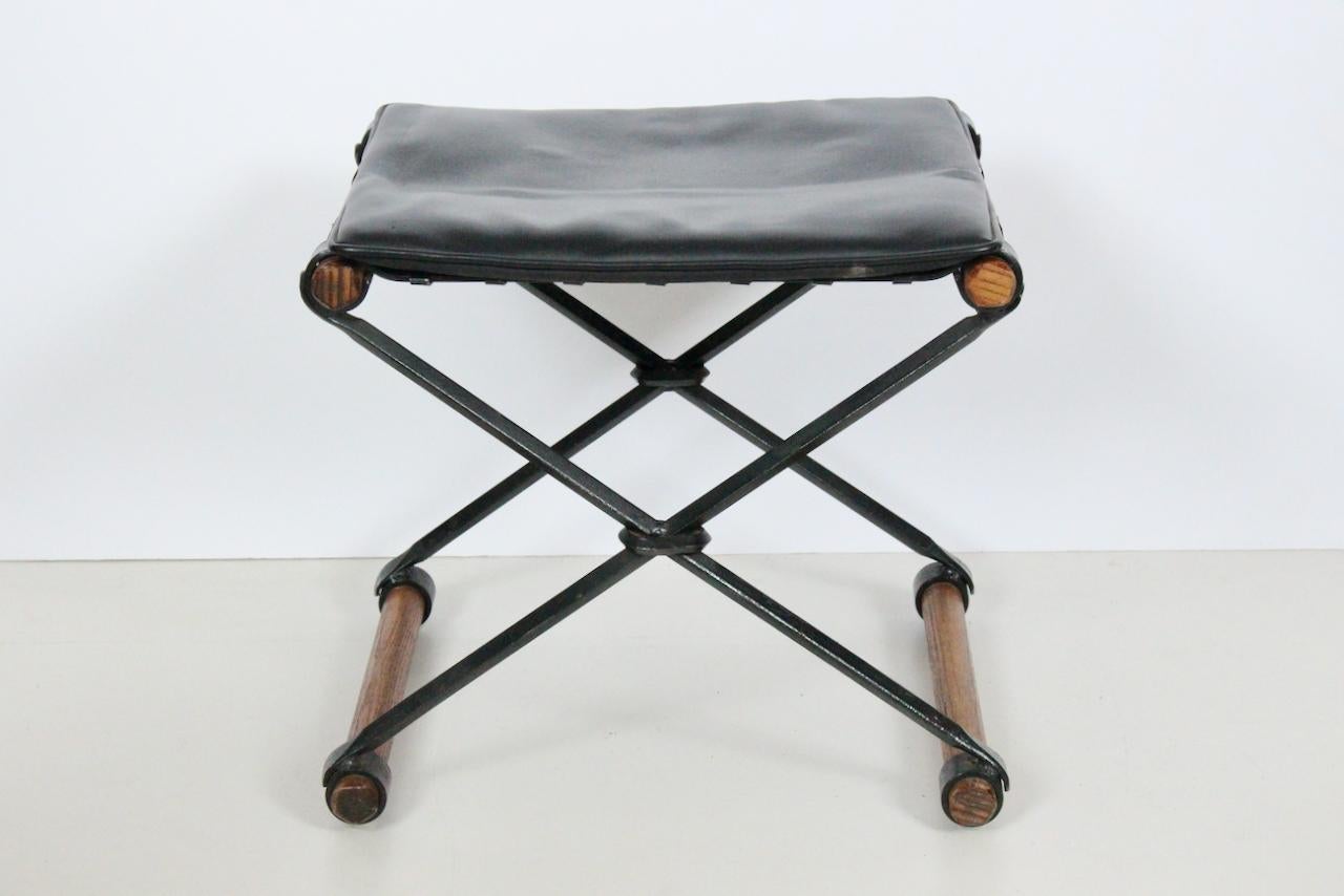 California Architect Cleo Baldon for Terra Furniture Iron, Oak & Leather X Bench. Featuring a reinforced blacked Wrought Iron X frame, taut Steel straps, burnished Oak dowels, original loose faux Black Leather seat cushion, Black Leather ties,  and