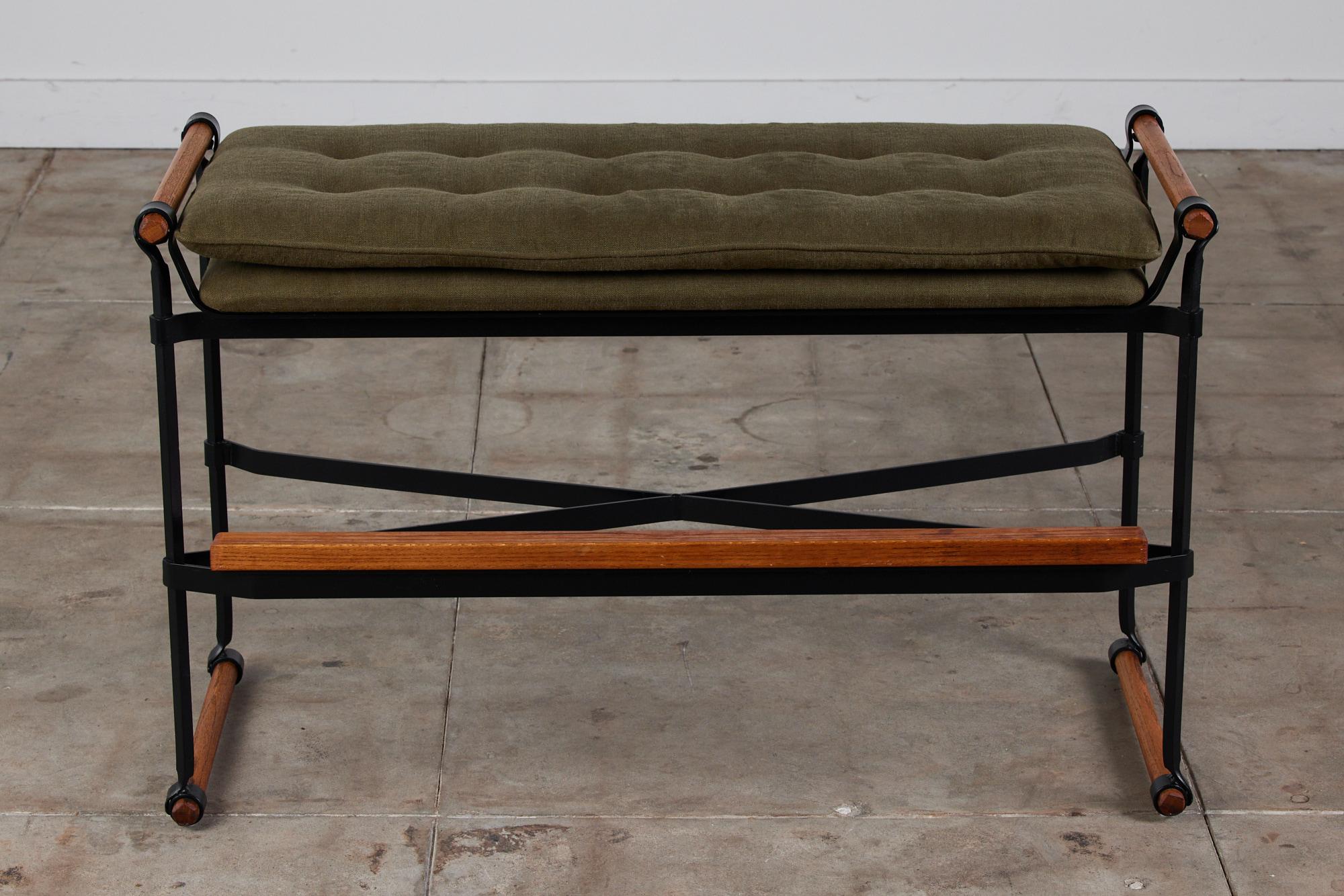 A Cleo Baldon bar height bench for Terra, USA, c.1960s. The bench features a wrought iron x-base. It is grounded by rounded dowels with the same design element mirrored at the seat cushion. A rectangular block bar runs the length of the bench