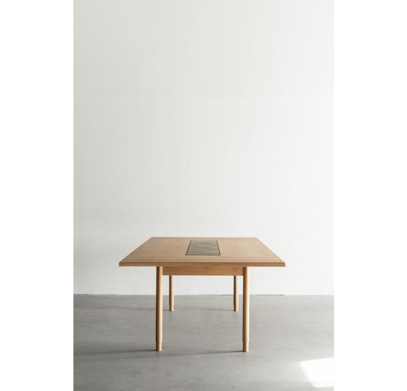 La table à manger Cleo est fabriquée à la main à Los Angeles, en Californie. Le plateau en bois massif de chêne est assemblé et coupé sur mesure avec un bord légèrement biseauté sur toute la longueur du plateau. Le plateau en chêne chevronné est