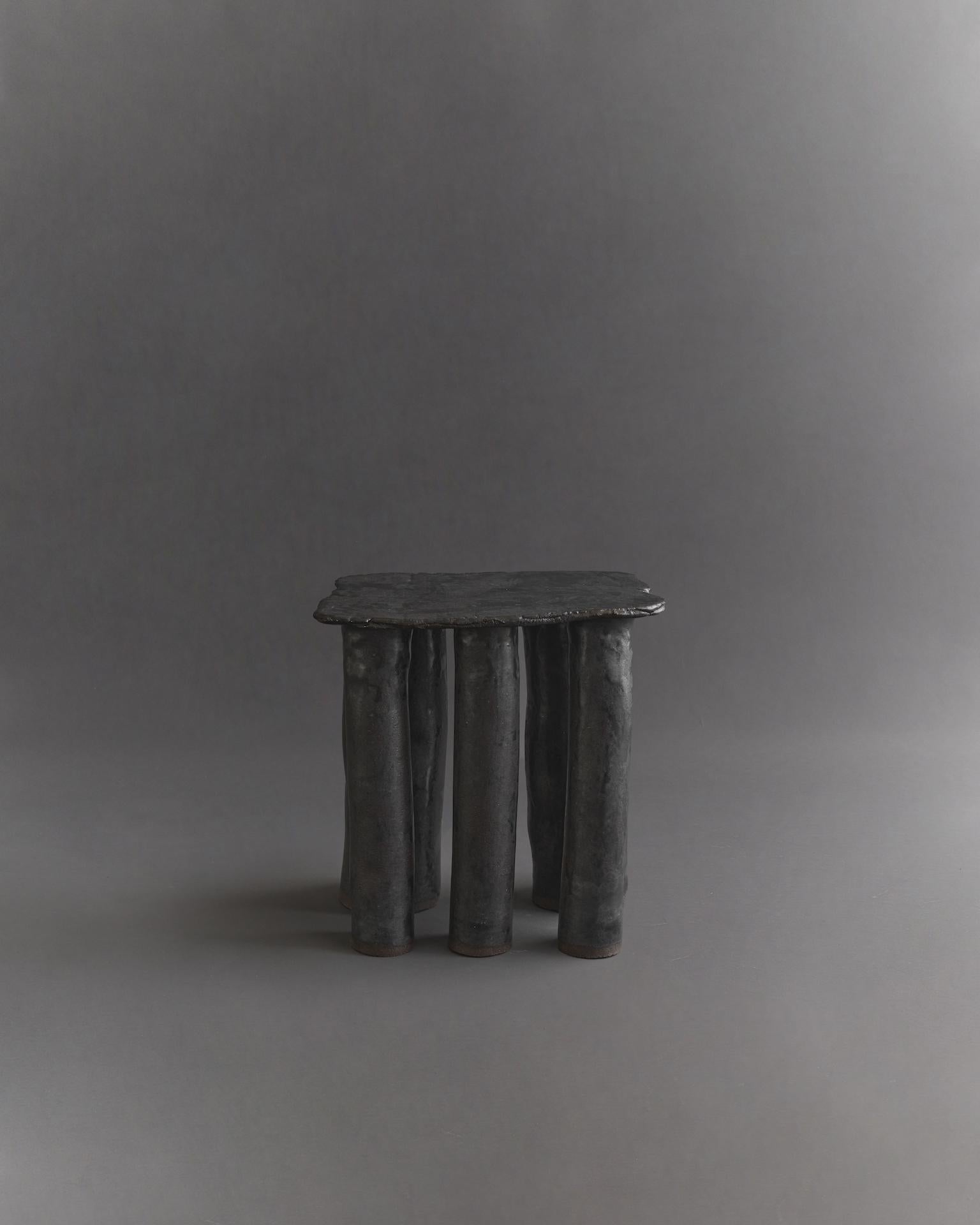 Inspired by stone slabs, this table embodies texture, organic shapes, and close attention to detail. The glaze almost has a metallic aspect to it, giving it a slight sheen. Each product is handmade to order, resulting in slight variations to the one