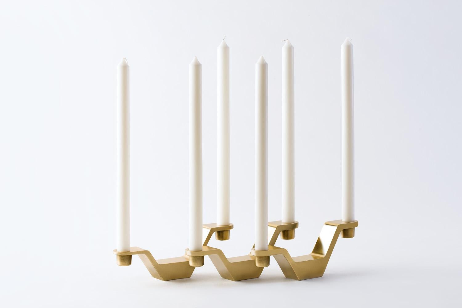 Cleo Candle Holder is designed by London based designer duo PearsonLloyd for GAIA&GINO, consisting of a brass handmade candleholder with two arms. Pearson Lloyd  implemented the same engineering principles to candle holders they apply to aircraft