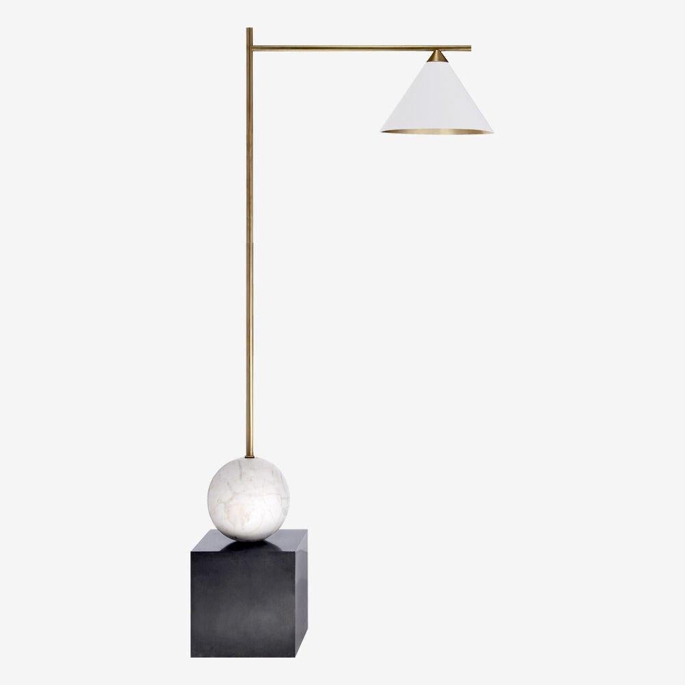 The Cleo floor lamp highlights the beauty of mixed materiality in bold geometric forms. This floor lamp features antique burnished brass and bronze detailing, a gilded shade interior, and the option of either an antique white shade with white marble