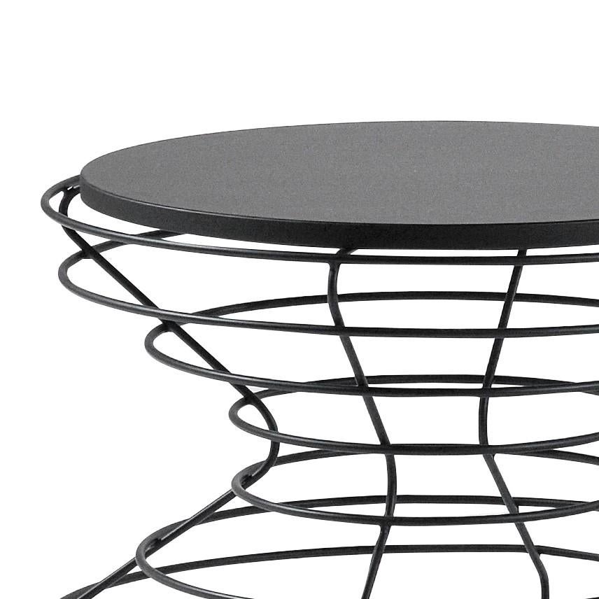 Entirely handcrafted by skilled craftsmen, this superb coffee table is brought to life through hand-arranging solid iron rods in black lacquered finish in an hourglass shape, creating an illusion of volume and lightness. The round top is made of MDF