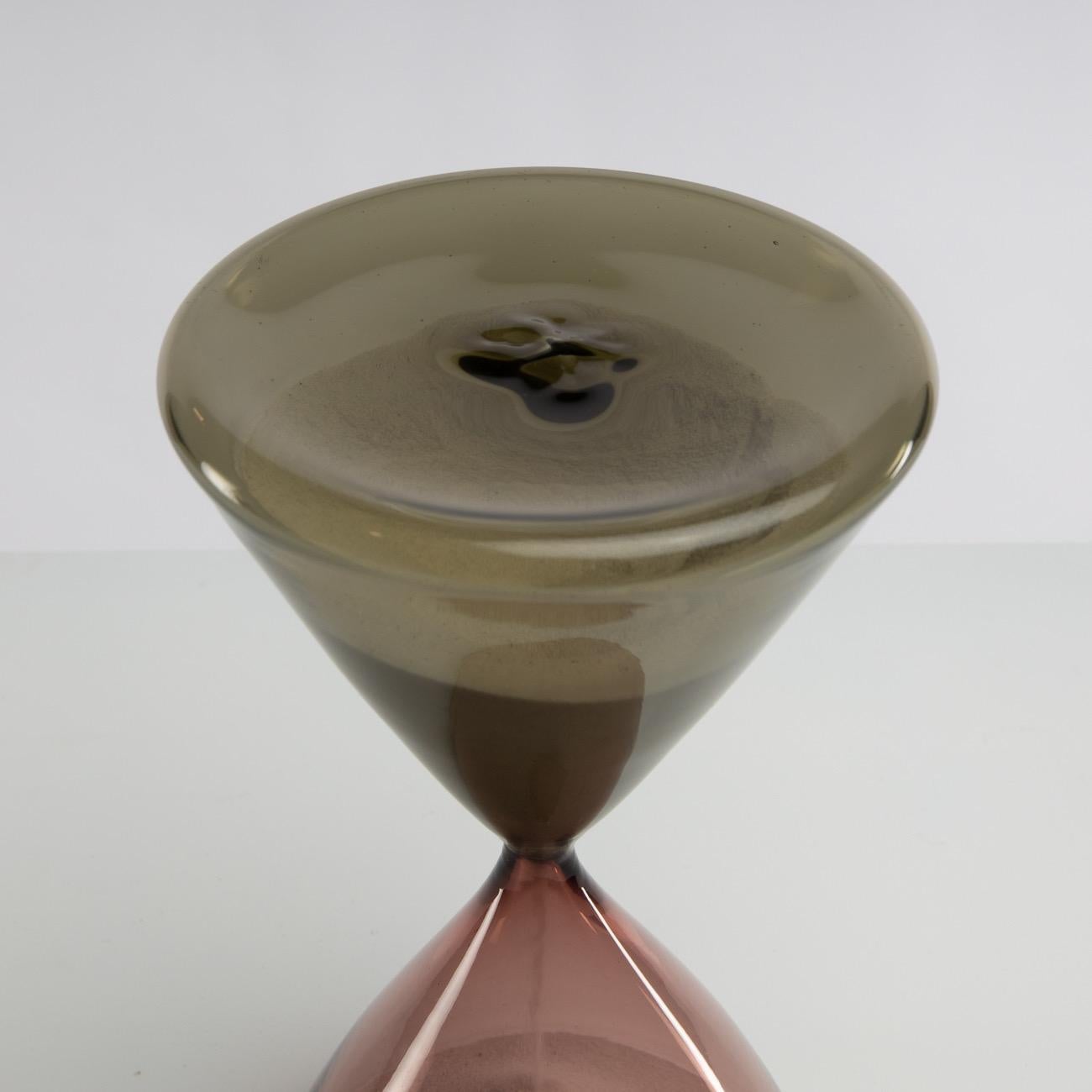 The hourglasses designed by Paolo Venini in 1957 were exhibited at the Triennale di Milano the same year. 
This piece is a large and rare model. The two parts have a conical shape and different colours: one is pink and the other is