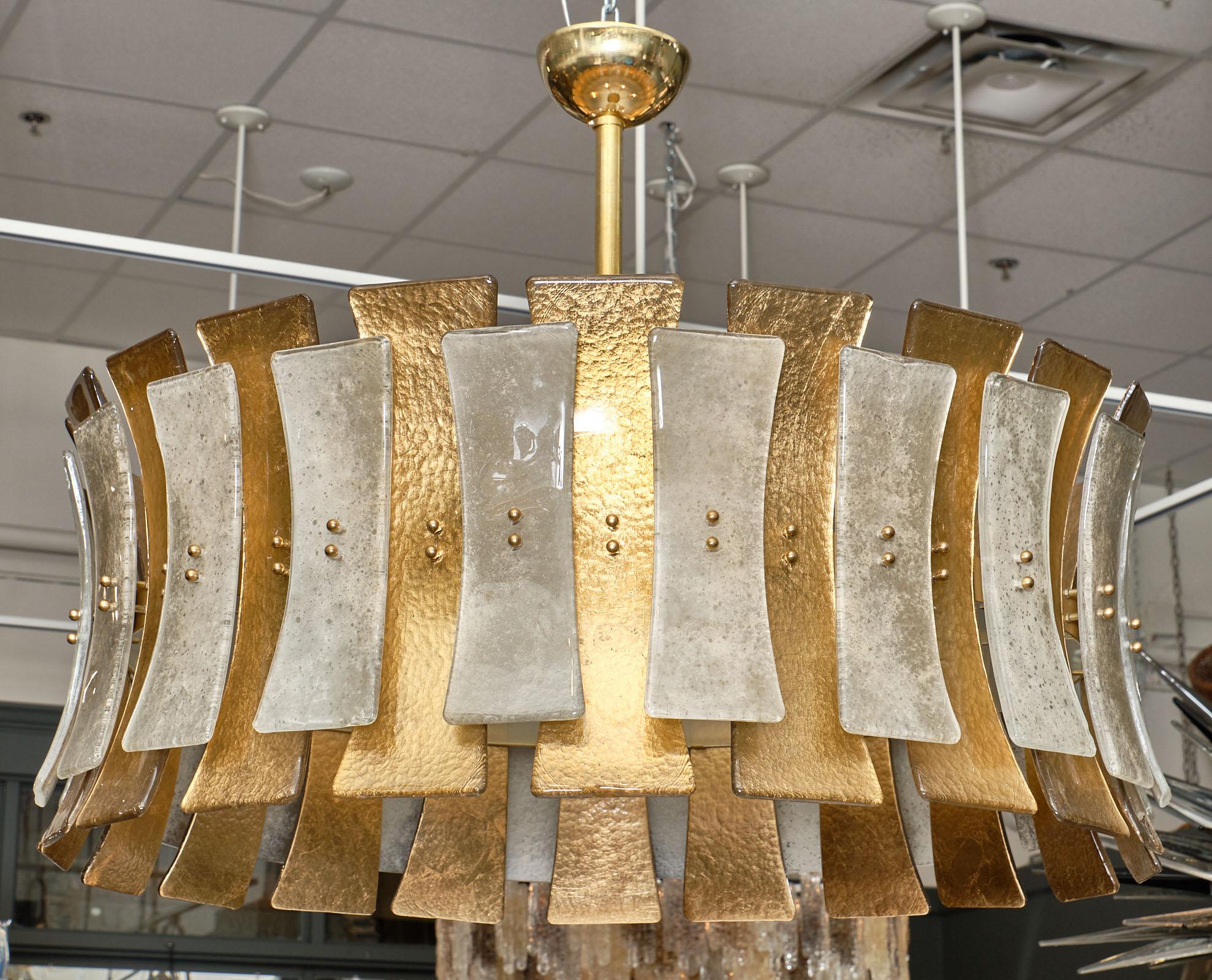 Murano glass “clessidre” chandelier with gold leaf fused glass elements in a drum-like style. The “clessidre” or hourglass shape of the glass creates elegant curves to this impressive fixture. It has been newly wired to fit US standards and hangs