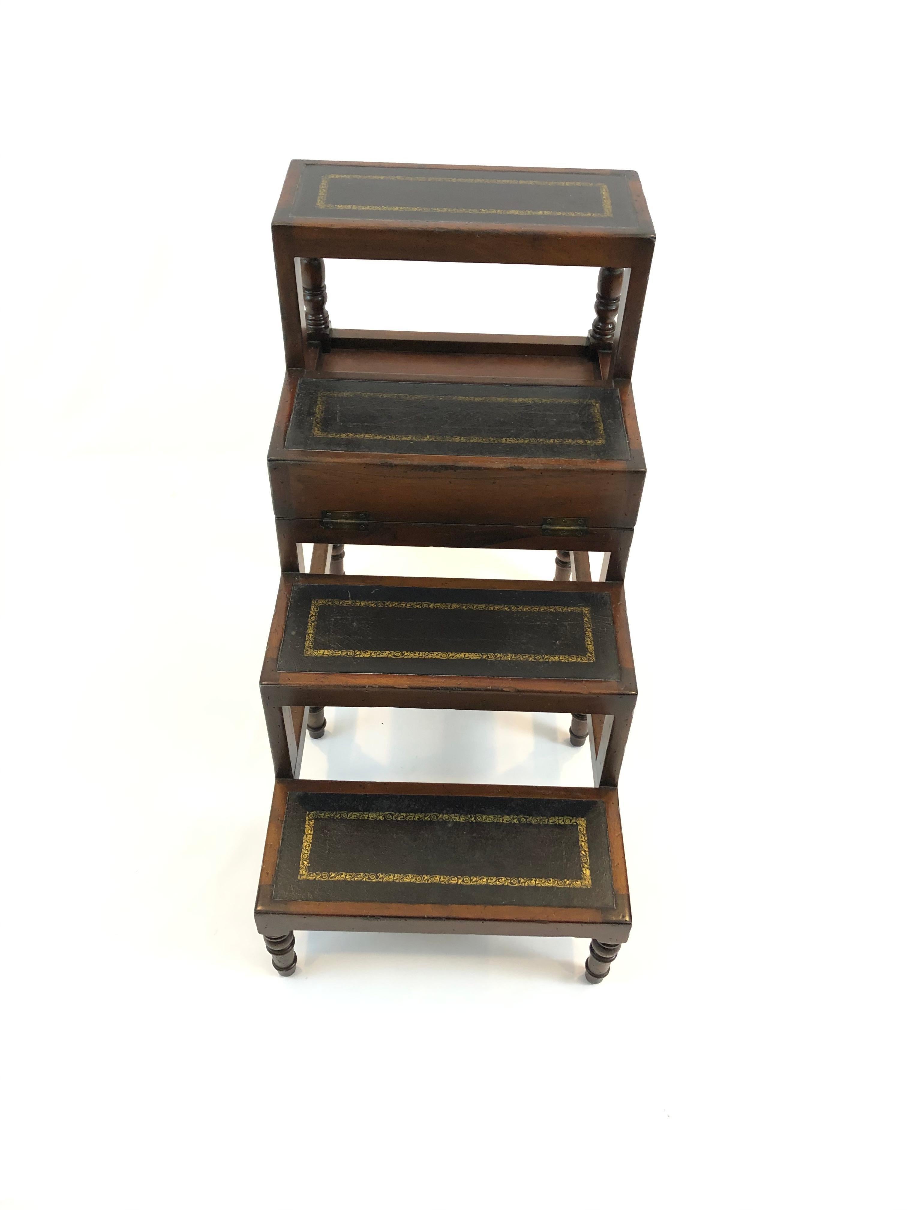 A cleverly designed versatile mahogany & black tooled leather set of library steps that converts to a rectangular coffee or end table. Legs are handsomely turned and risers or top of table have luscious craquelure and gold embossed decoration.