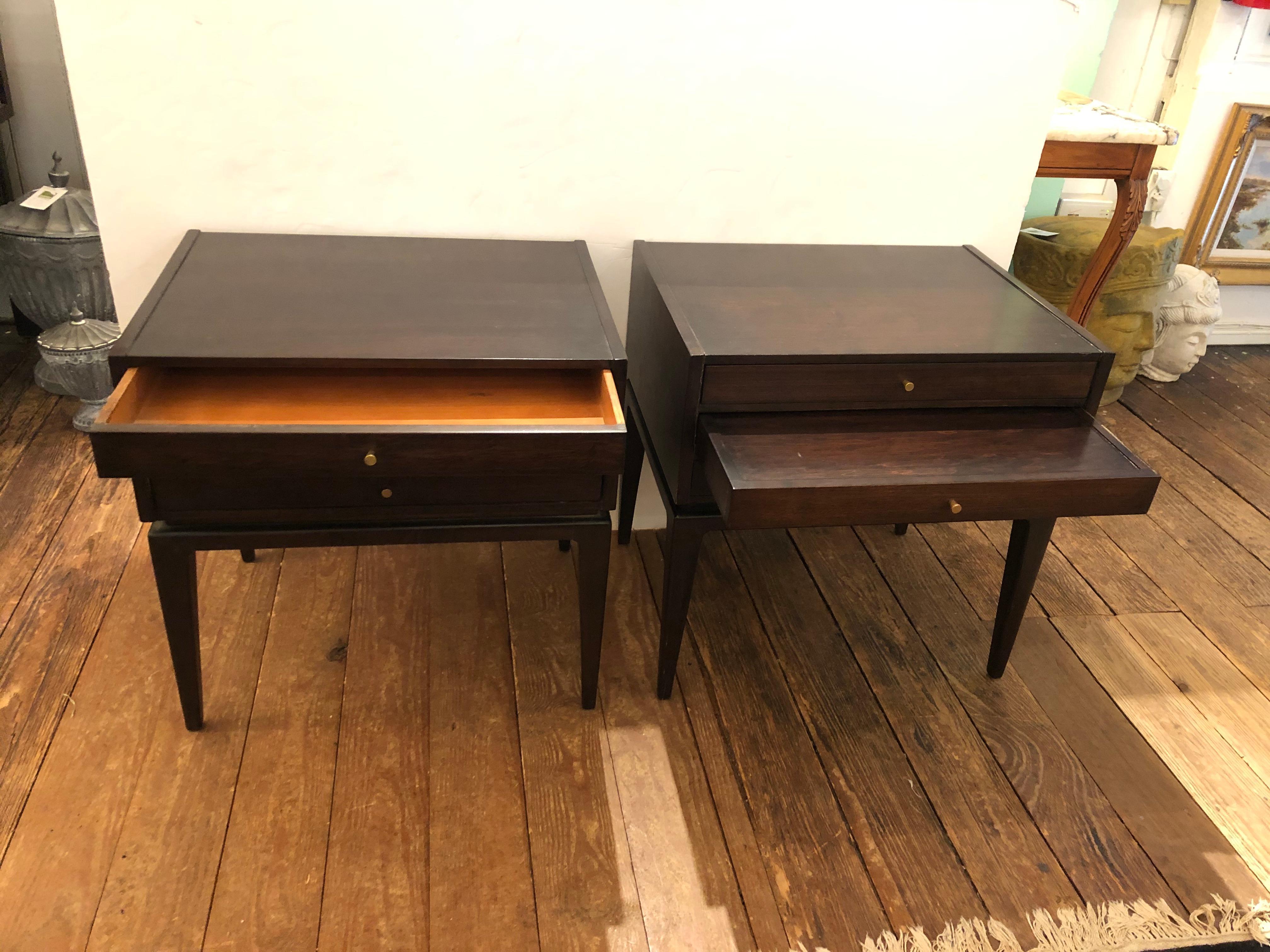 Very versatile and ingeniously designed pair of mahogany Mid-Century Modern end tables with Danish modern Silhouette, having what looks like three drawers, but in actuality each has a top single drawer over two pull out collapsible sturdy serving