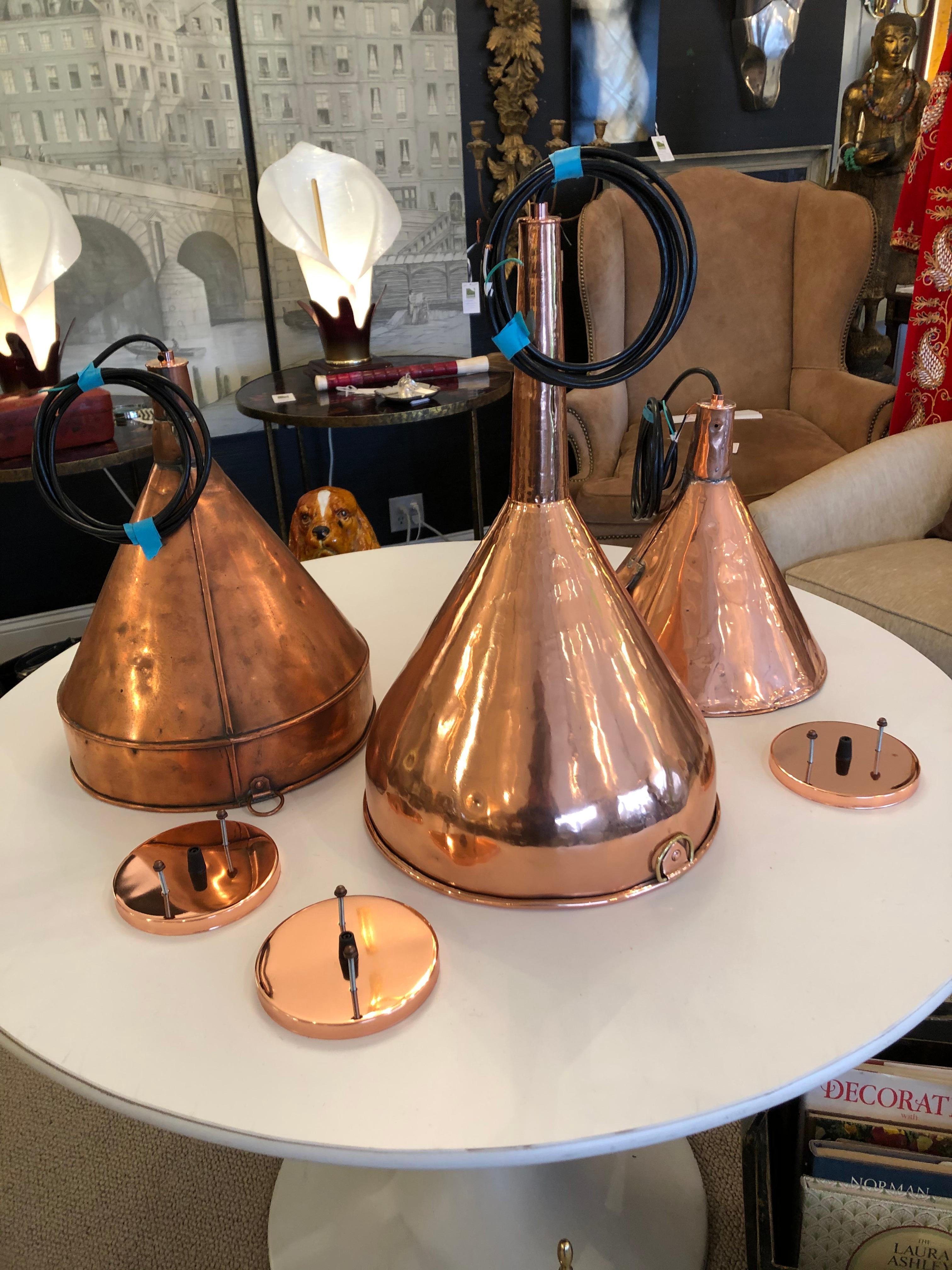 Marvelous trio of varied antique copper funnels cleverly electrified and transformed into light pendants.
Each takes 60 watt bulb.
Measures: Large: 20.75 height, 12.5 diameter
Medium: 16.5 height, 12.25 diameter
Small: 12.5 height, 13.5