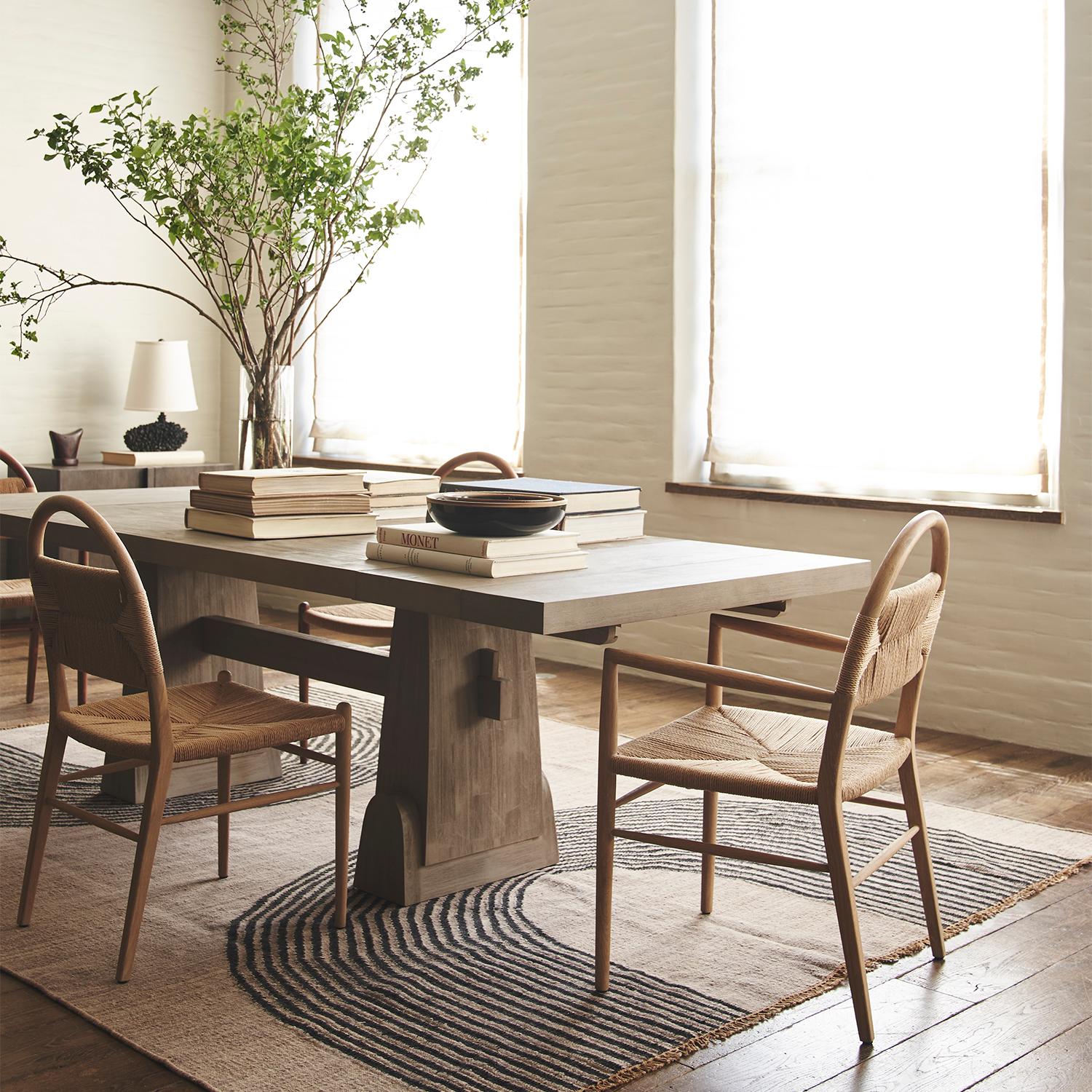 This elegant, minimalist dining table draws on design history from Swedish farm style to mid-century sculpture, and a driftwood finish adds a modern, versatile update to suit any décor.