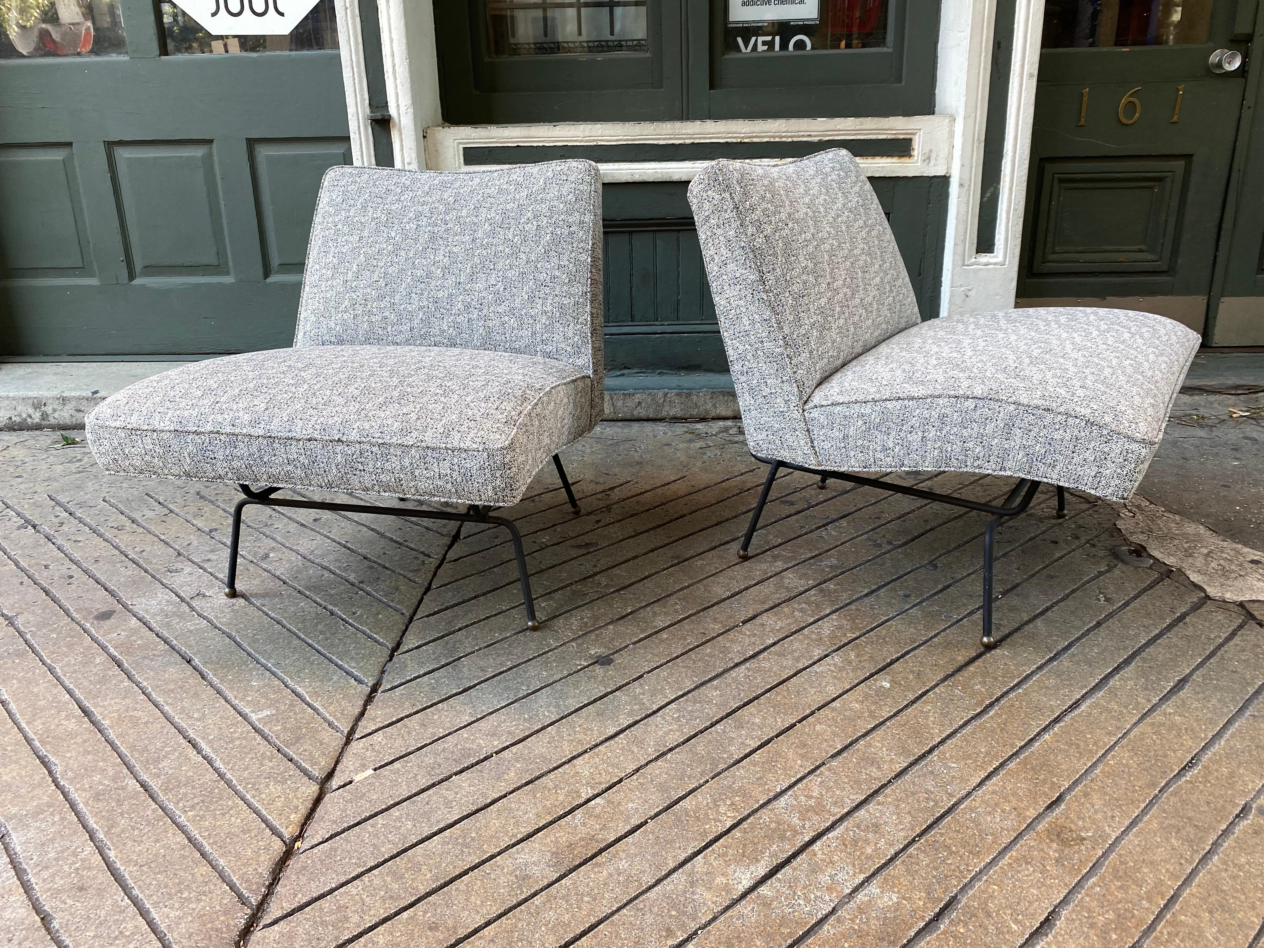 Pair of metal lounge chairs, with upholstered seat and back with brass ball feet. Often said to be designed by Clifford Pascoe, Dan Johnson or Allan Gould.....among many others. These Chairs retain a 1953 label that shows a NYC address. Very
