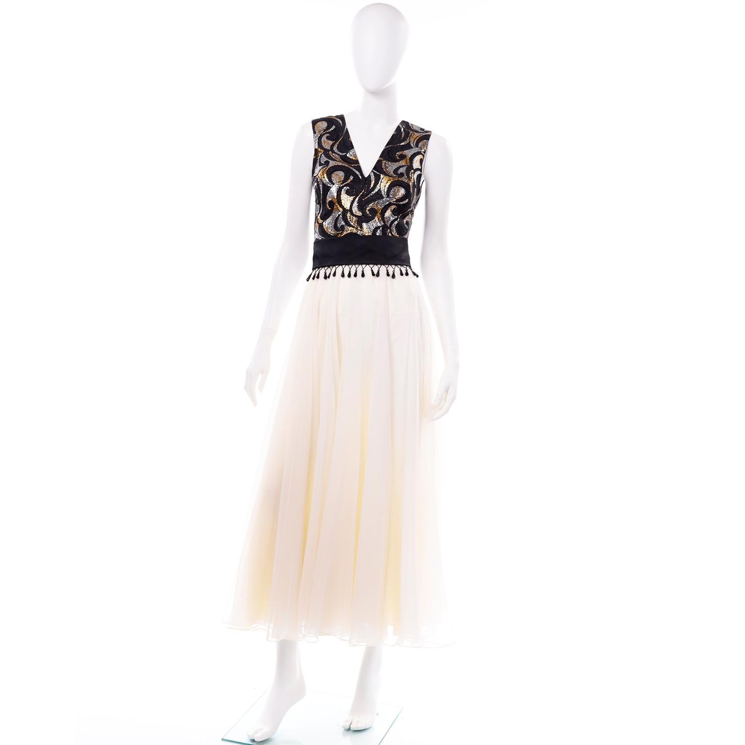 This is such an amazing Clifton Wilhite Dallas vintage evening dress. This is a very feminine sleeveless dress with black taffeta silk beaded tassel belt. The V neck bodice of the dress has black swirls and metallic gold and silver lamé and is lined