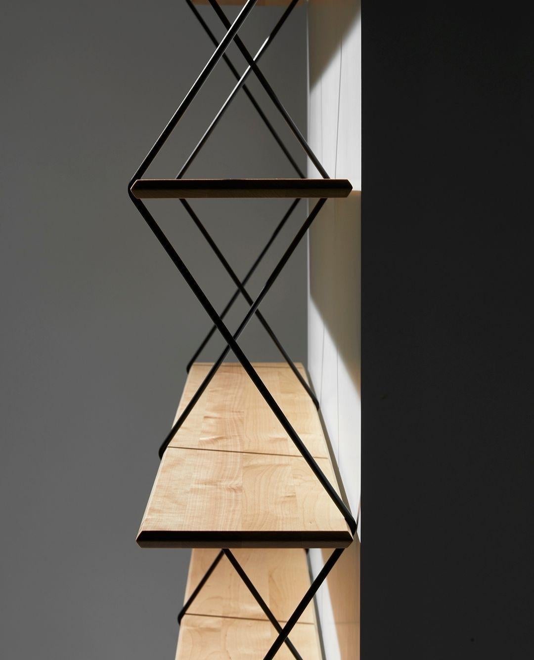 Climb is an ingenious shelving system made of beveled wooden boards supported by metal wires.

The design plays with the sensation of tension of the wires that grasps the wooden shelves and becomes a rigid structure as the product is assembled.