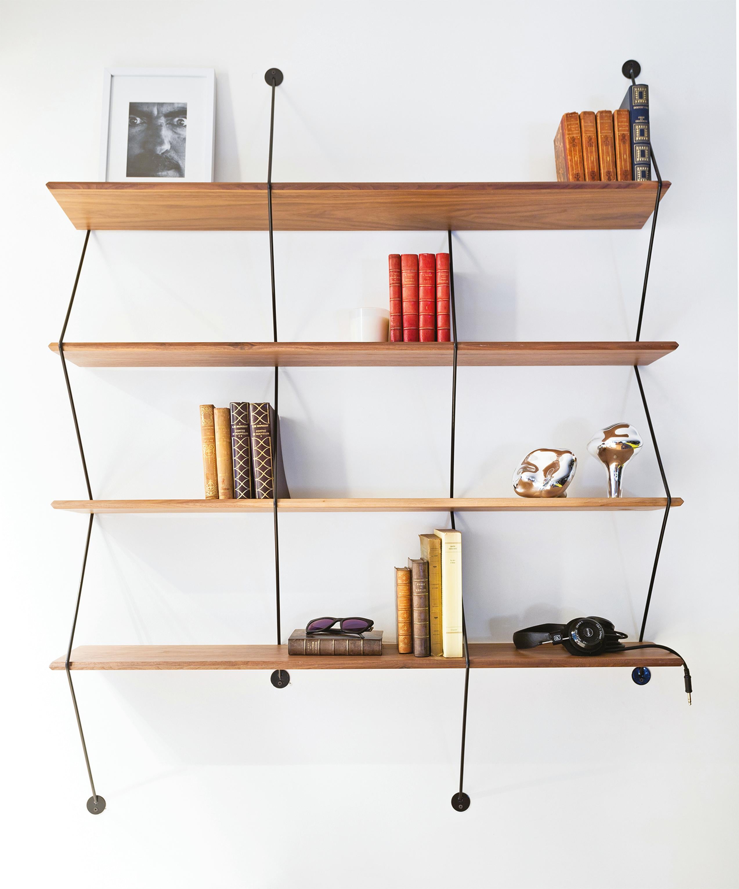 Climb is an ingenious shelving system made of beveled wooden boards supported by metal wires. Measure: 120 cm.
The design plays with the sensation of tension of the wires that grasps the wooden shelves and becomes a rigid structure as the product