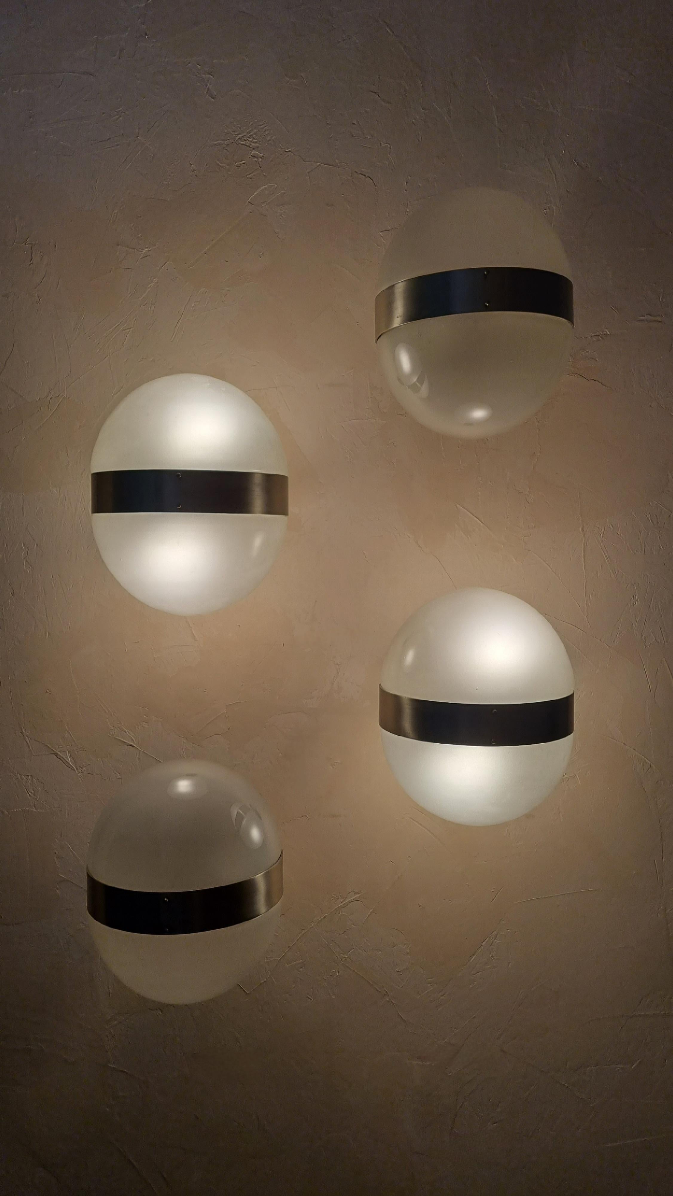 Set of 4 Clio wall sconces designed by Sergio Mazza for Artemide in the 1963, frosted glass lampshade , structure in nickel-plated brass, each lamp  superimposed 2 light points that emit a warm and soft light. mounts E 27 bulbs.
Excellent