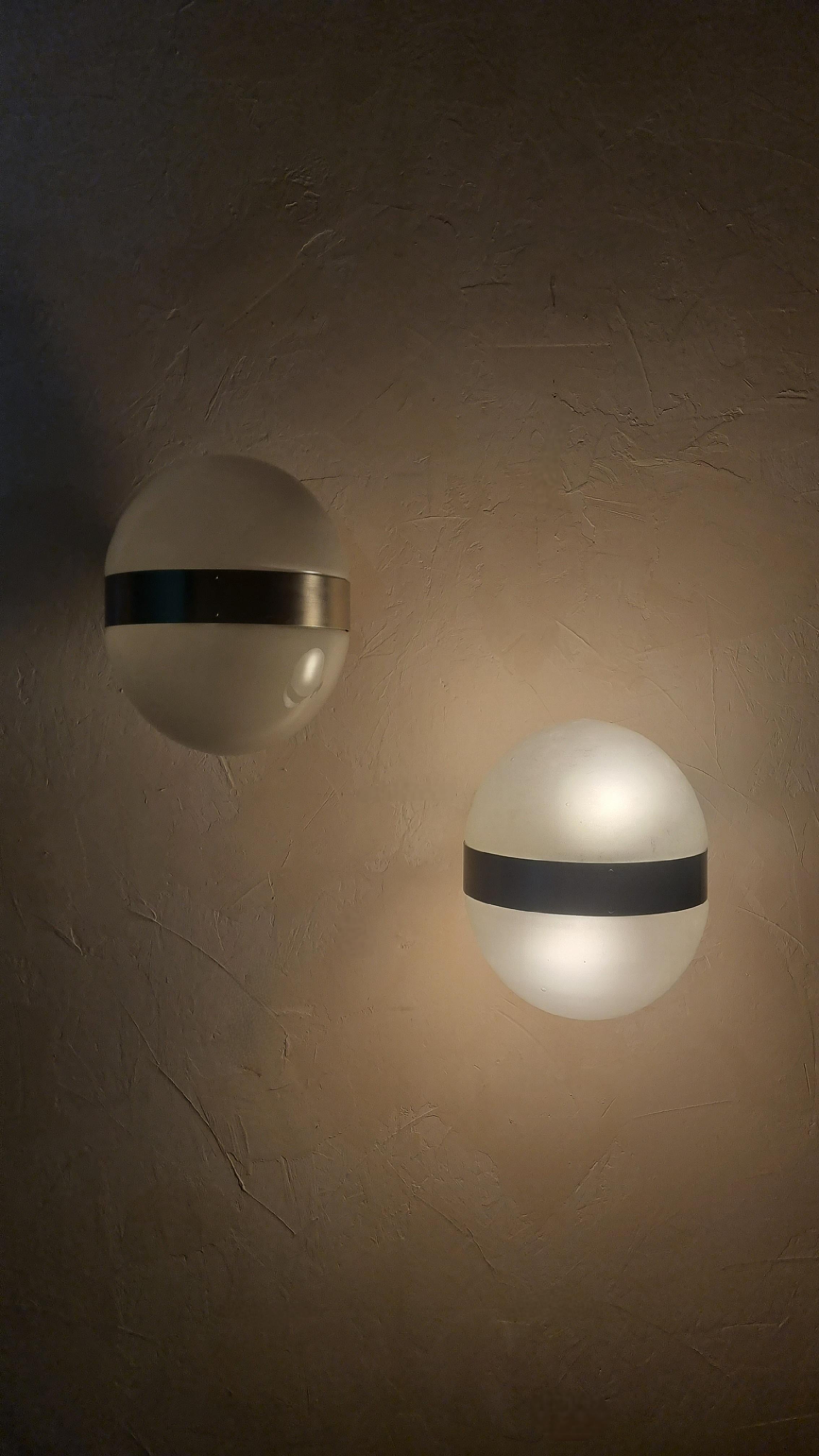 Pair of 2 Clio wall sconces designed by Sergio Mazza for Artemide in the 1963, frosted glass lampshade , structure in nickel-plated brass, each lamp  superimposed 2 light points that emit a warm and soft light. mounts E 27 bulbs.
Excellent