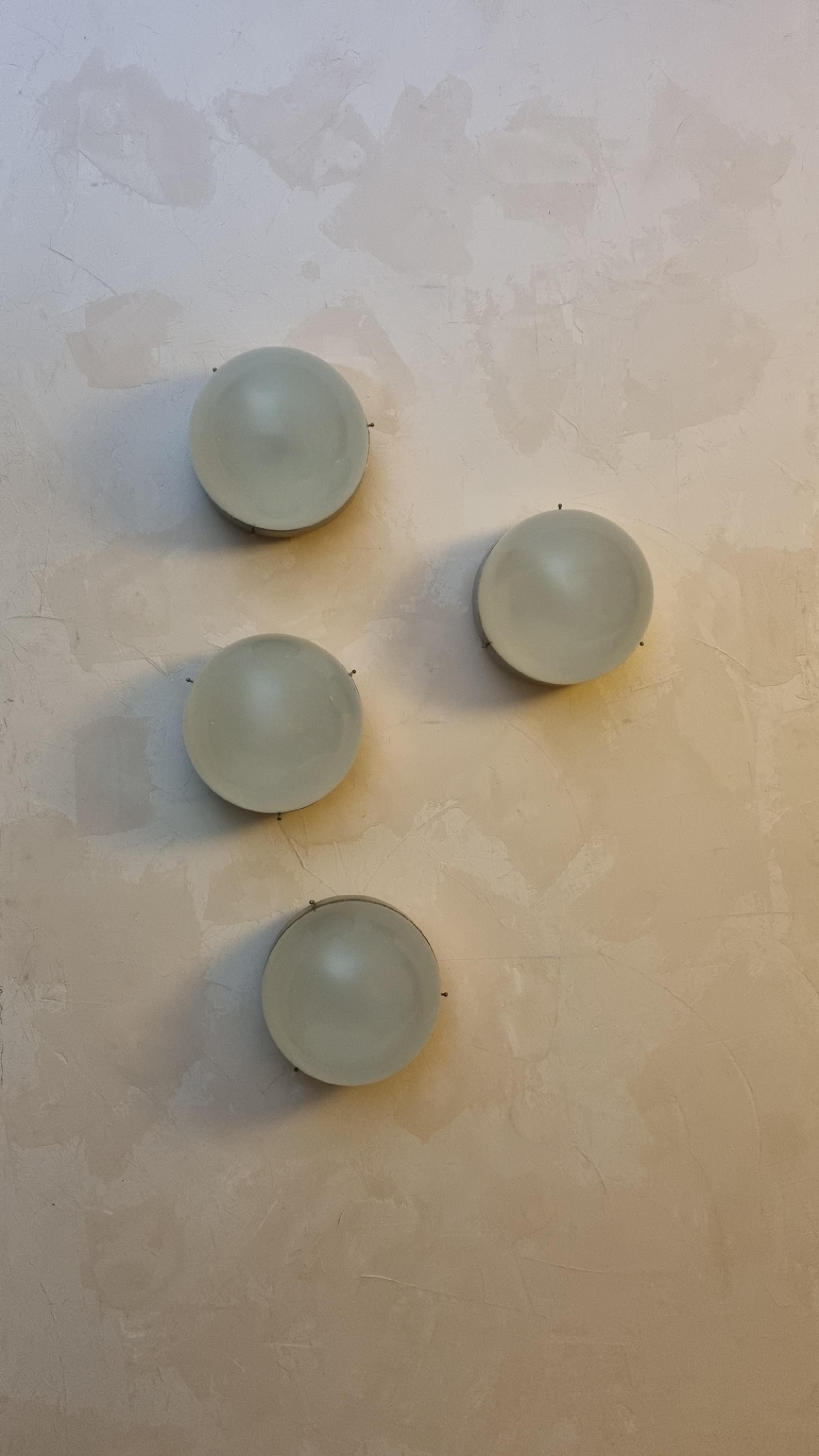 Set of 4 Clio wall sconces designed by Sergio Mazza for Artemide in the 1963, frosted glass lampshade , structure in nickel-plated brass, each lamp  superimposed 1 light points that emit a warm and soft light. mounts E 27 bulbs.
Excellent
