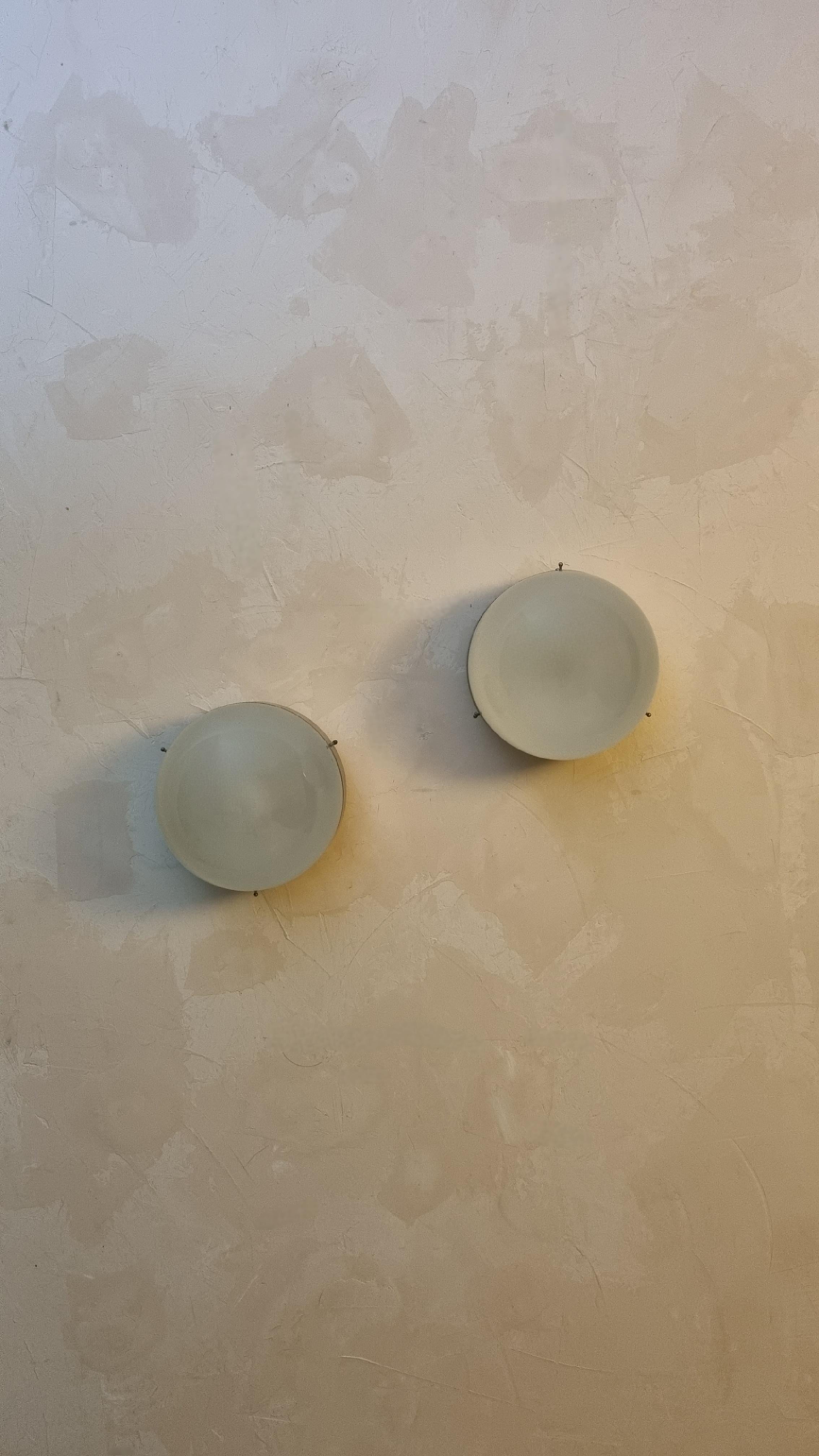 Pair of Clio wall sconces designed by Sergio Mazza for Artemide in the 1963, frosted glass lampshade , structure in nickel-plated brass, each lamp  superimposed 1 light points that emit a warm and soft light. mounts E 27 bulbs.
Excellent conditions,