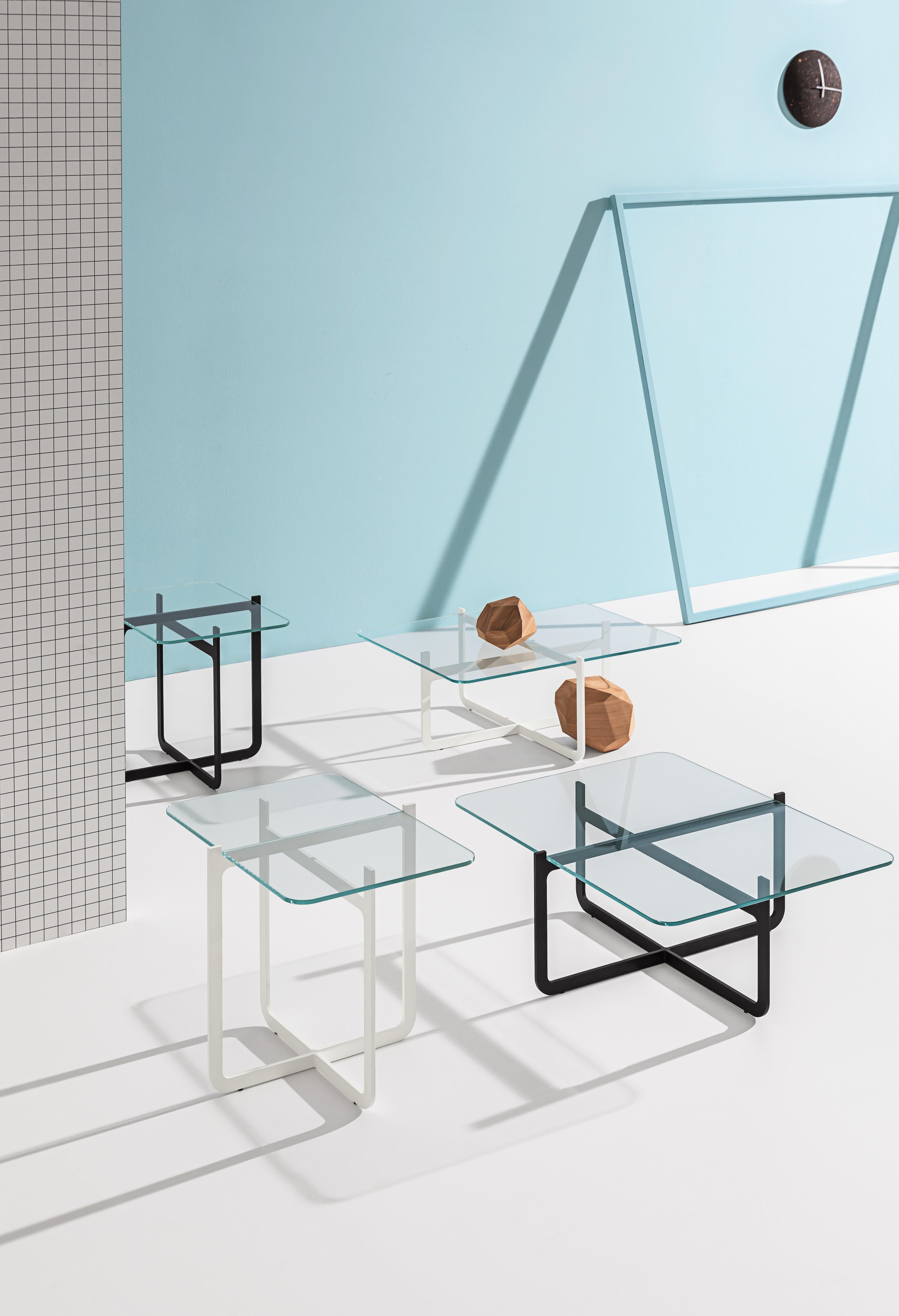 Coffee table with laser-cut, welded metal lacquered in black and tempered extra clear glass top.

Nendo seeks simplicity and minimalism with this combination of metal and glass. Clip comes to life from the concept of two steel sheets cut out like