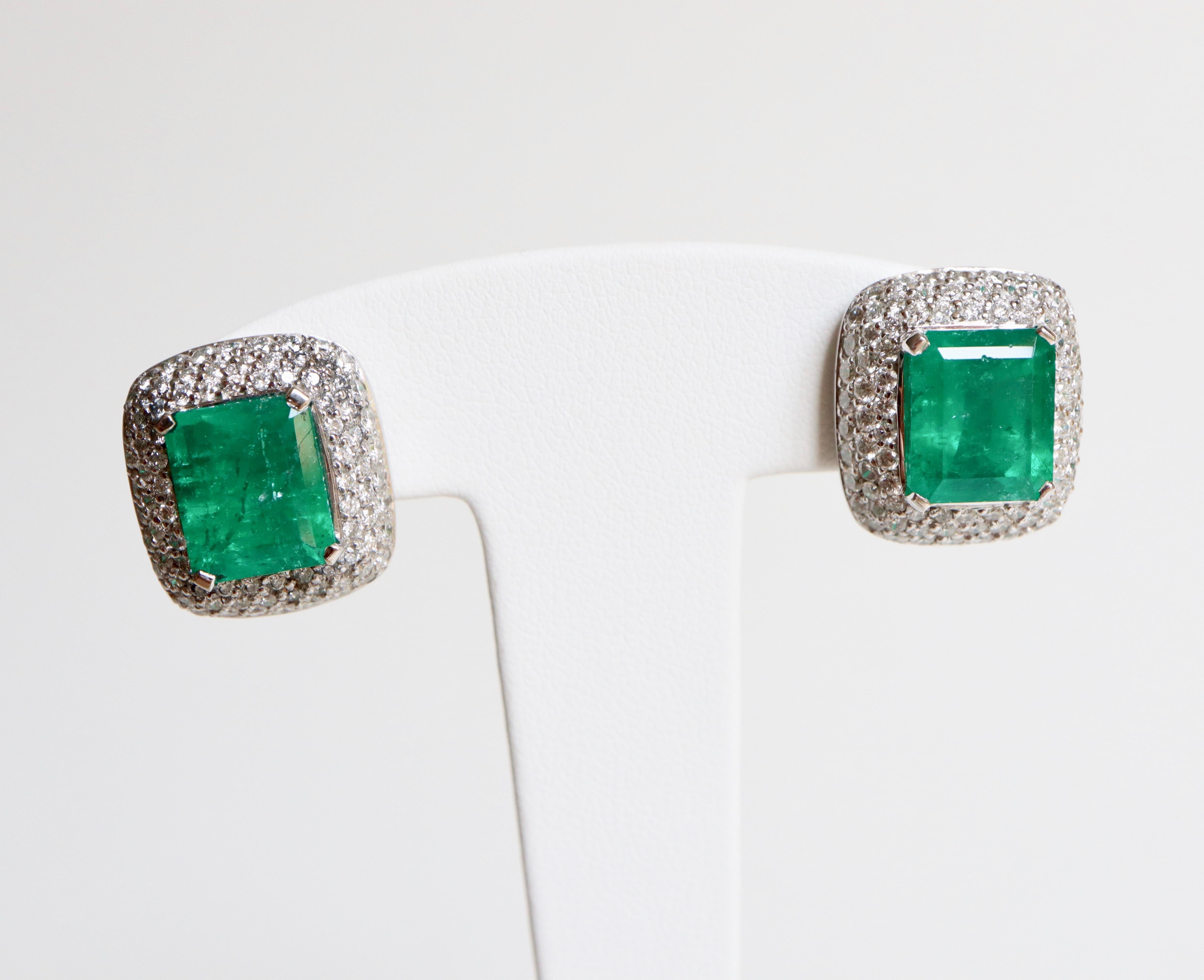 Boucles d'oreilles clips en or blanc 18 carats contenant en leur centre une émeraude de 4,57 carats et 5,45 carats sertie de griffes entourées de diamants sertis à grains pour un poids d'environ 1,5 carats de diamants sur chaque clip pour un total