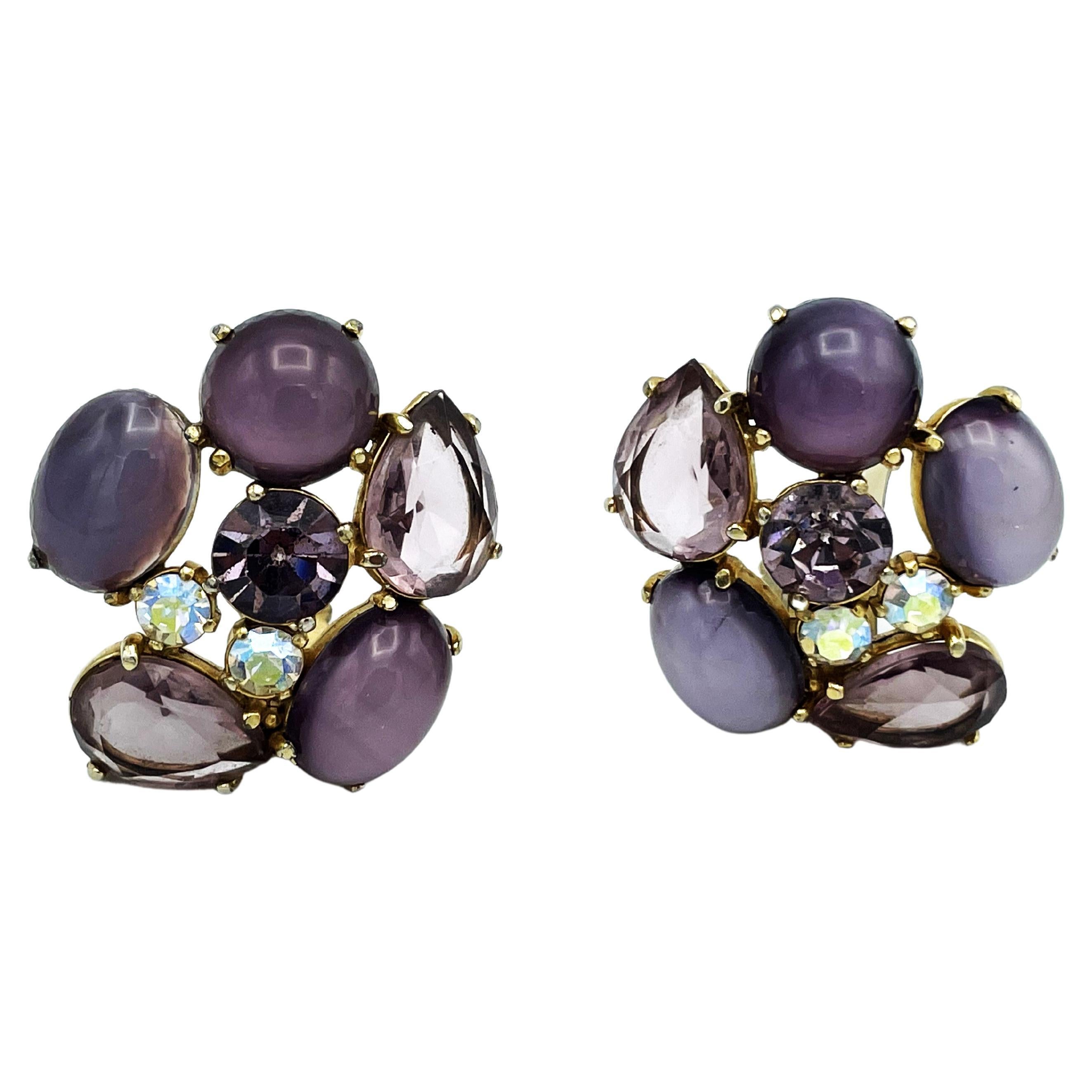 Vintage ear clips consisting of light purple round and cut large and small rhinestones, designed by Schiaparelli Italy 1950s.
Measurement
Height 4,5 cm  x  Width 4 cm, the largest stone 1,8 cm x 1,3 cm, the clear round stone in the middle 1 cm in