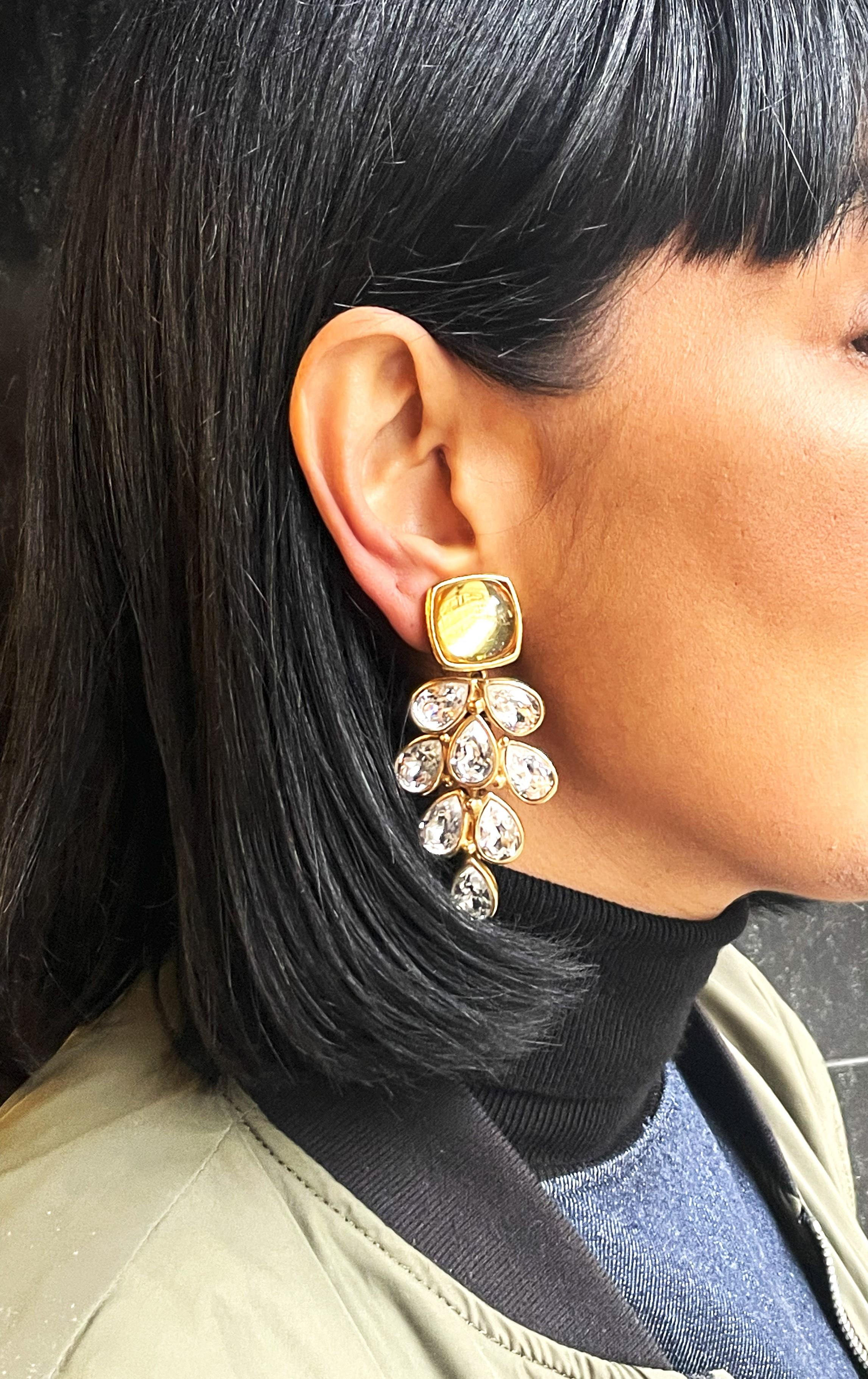 Clip-on earring form Robert Goossens Paris. 

Dimension:
Length 7 cm x W 3,5 cm 

Feature.
-  Singed Goossens Paris, backside
-  On top 2 x 2 cm gold tone Resin 
-  Dangling & cut rhinestones in gold-plated setting
-  Very good condition
