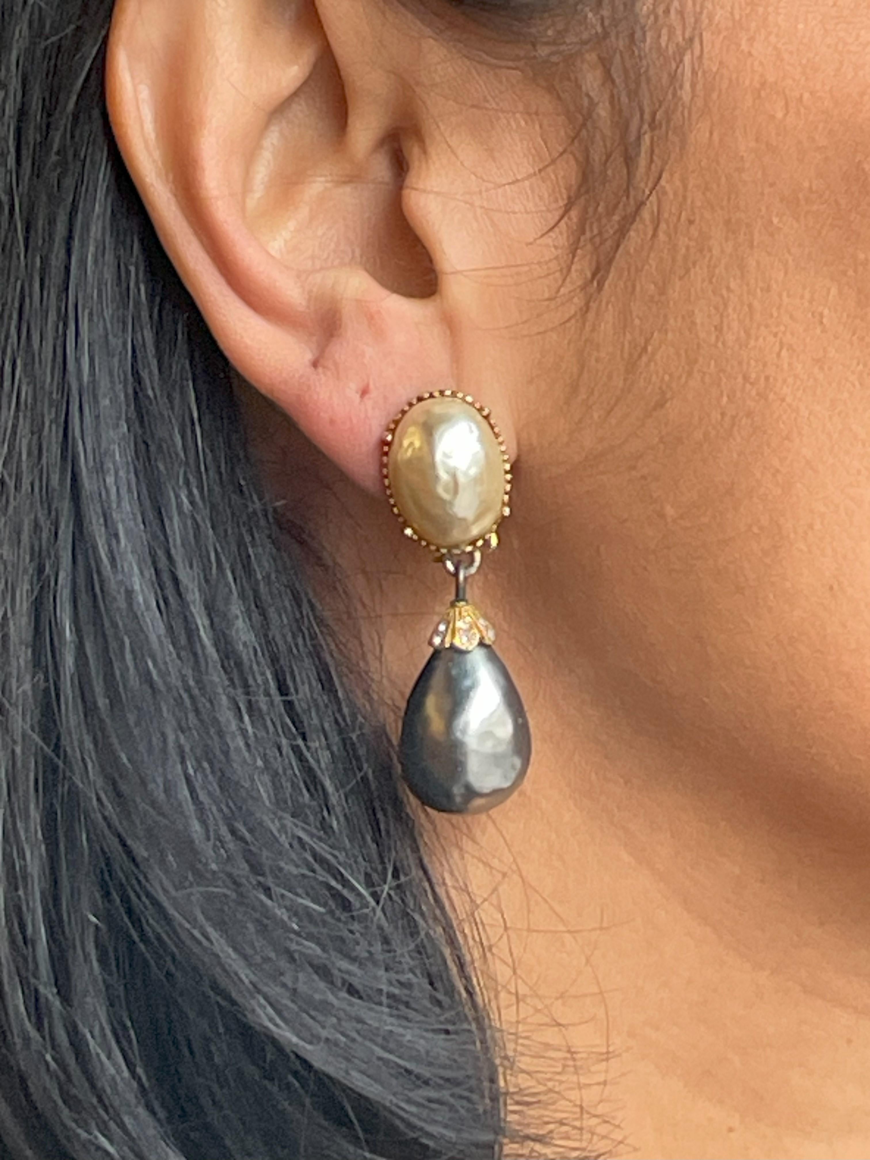 Very beautiful versatile wearable ear clips, consist of an oval natural colored artificial pearl with a dark grey silver artificial pearl hanging from it,  to match the following Chanel Sautois. Signed MOSELL US around 1950s

Dimensions:
Length 4.8