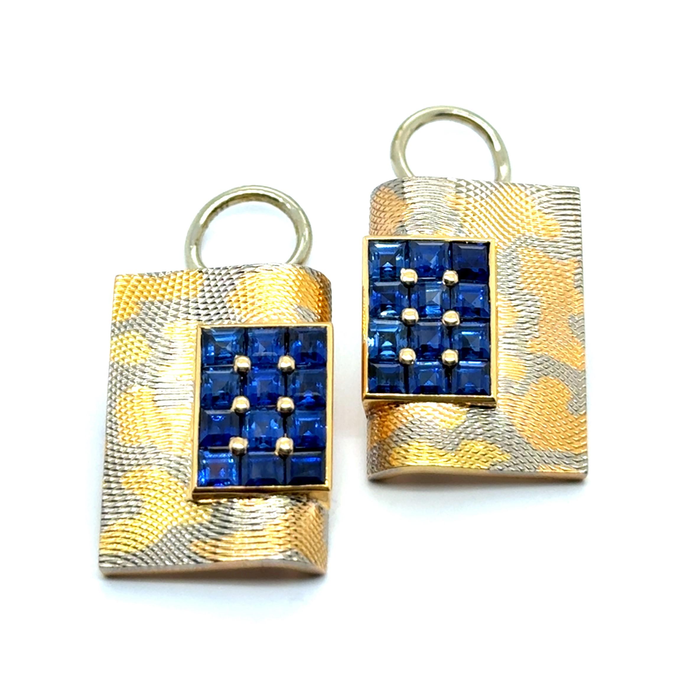 These elegant earrings feature a striking design with 24 blue sapphires totaling 2.40 carats. The sapphires are meticulously arranged in a grid pattern, their rich royal blue hue creating a stunning visual contrast against the radiant 18-karat
