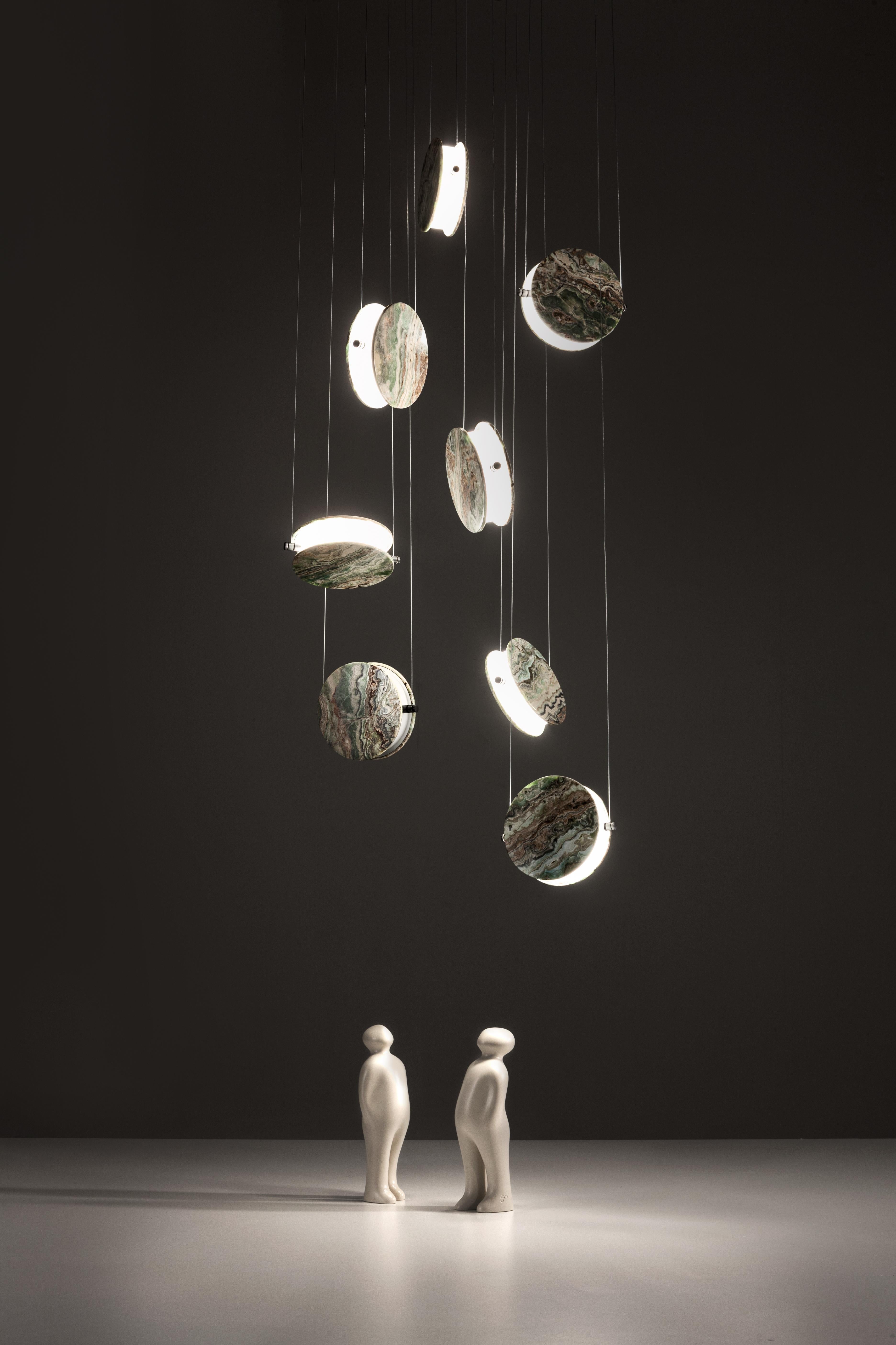 Lampada a sospensione Clis di Laurameroni
Dimensioni: L 60 x P 60 x H 400 cm
Materiali: Onice verde. 

Lampada a sospensione con rosone in bronzo scuro, cavi in acciaio per la trasmissione della corrente, corpo illuminante in PMMA e metallo e 8