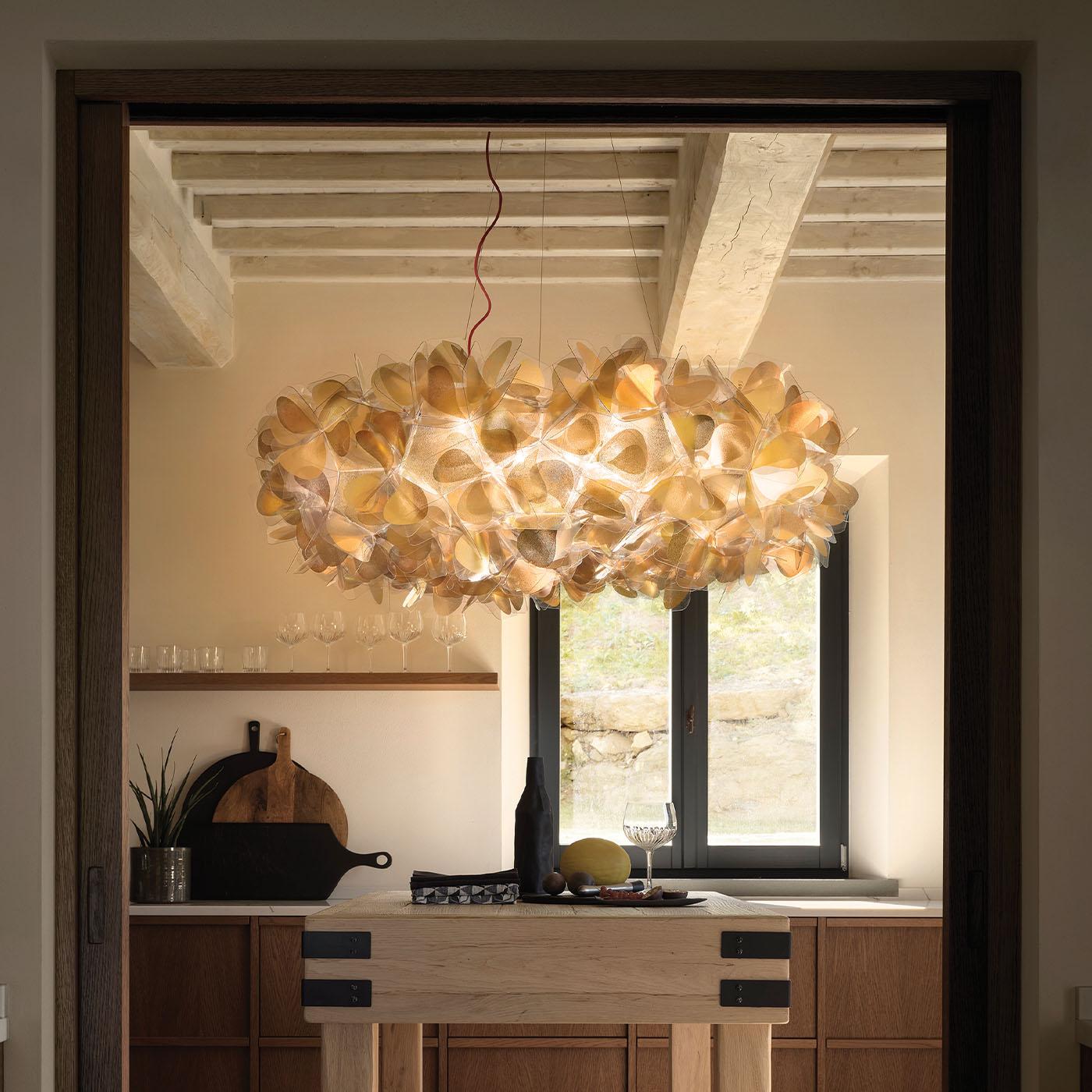 An ode to femininity and nature, this bouquet-like polycarbonate/cristalflex chandelier is sure to capture the eye in any interior decor. Its romantic aesthetic results from the cold application of two-faced golden foils to the technopolymer