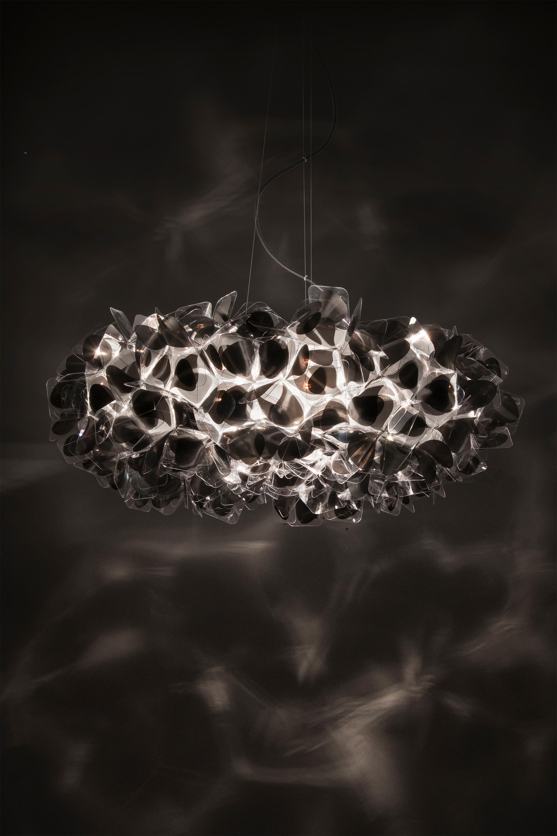 Clizia Mama Non Mama is a suspension inspired by pure natural beauty, with almost weightless petals that bring balanced allure and a fresh feel to interiors. A hand-folded bouquet of Cristalflex® is an ode to joy, femininity, primordial affection,