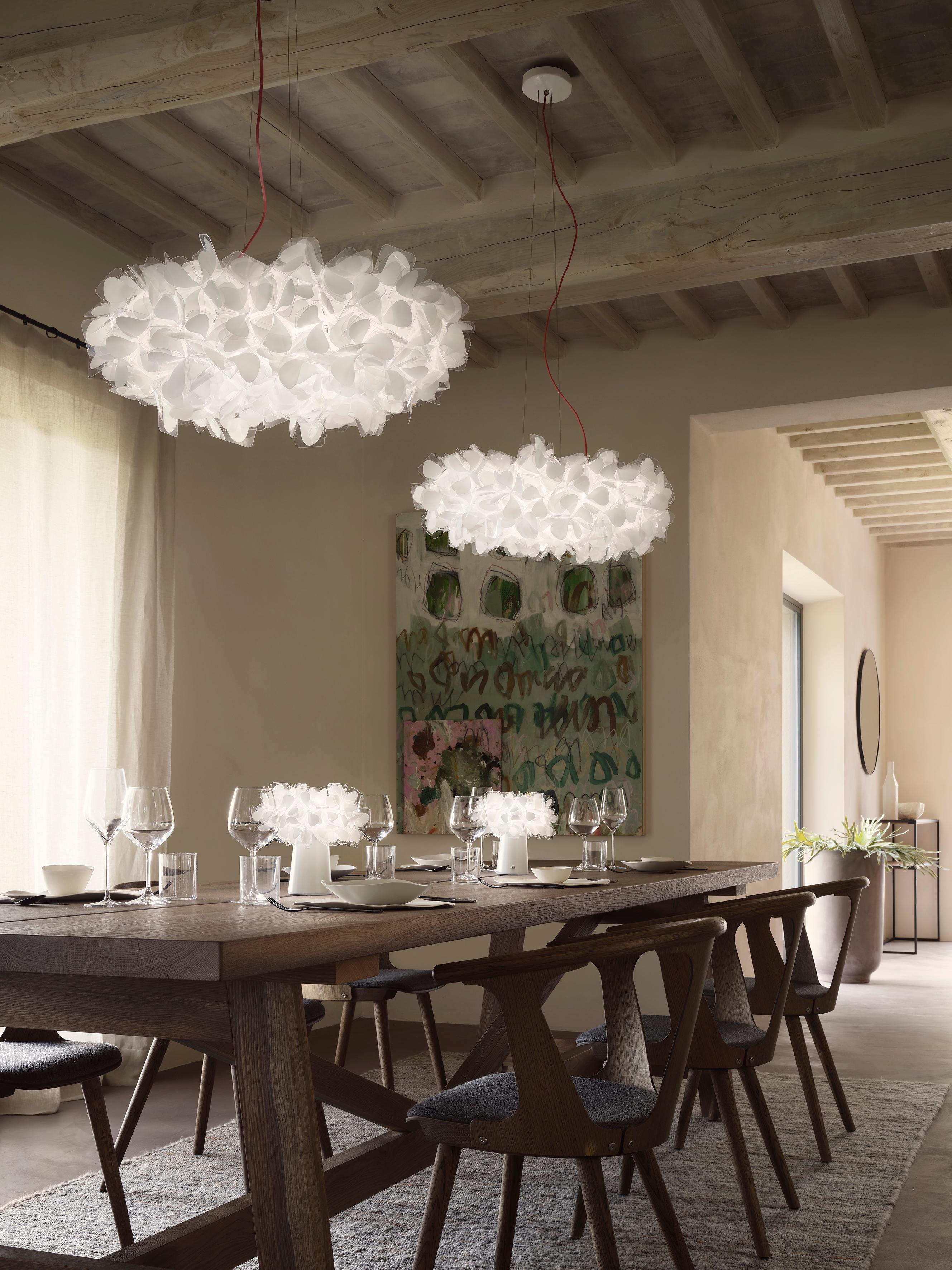 Clizia Mama Non Mama es una suspensión inspirada en la belleza natural pura, con pétalos casi ingrávidos que aportan un encanto equilibrado y una sensación de frescura a los interiores. Un ramo de Cristalflex® doblado a mano es una oda a la alegría,