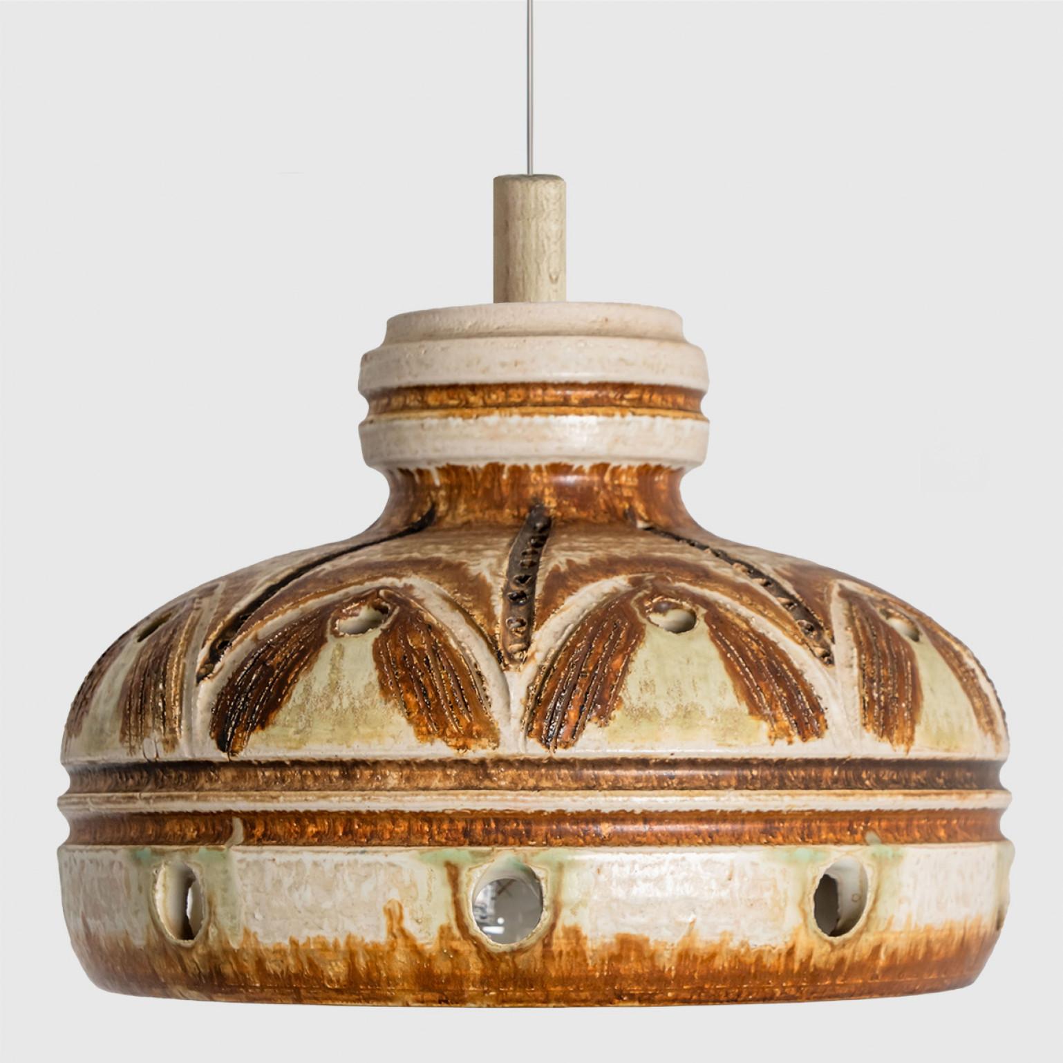 Stunning round hanging lamp with an unusual shape, made with rich ivory and terra colored ceramics, manufactured in the 1970s in Denmark. We also have a multitude of unique colored ceramic light sets and arrangements, all available on the