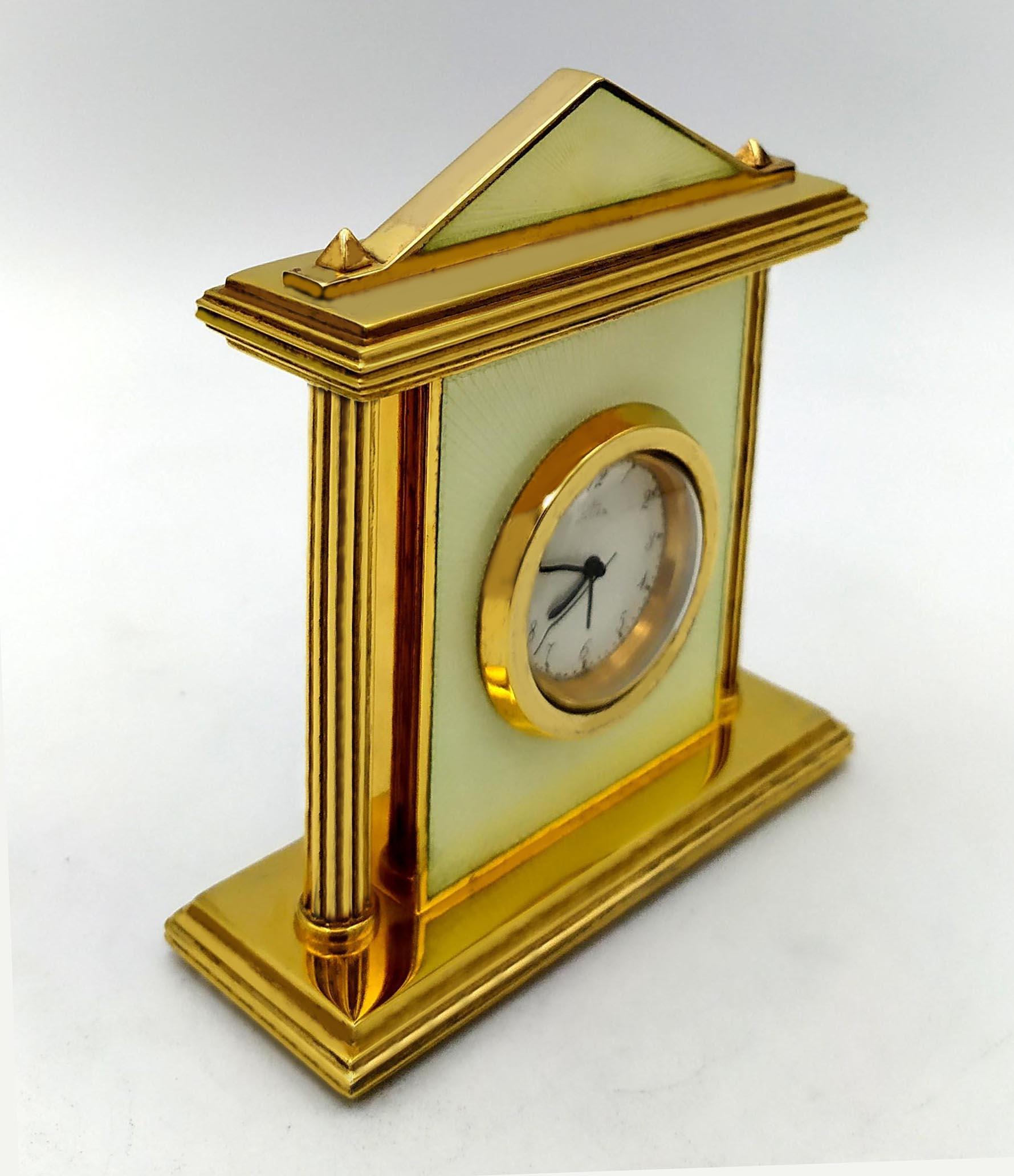 Small table clock in gold-plated 925/1000 sterling silver with translucent enamel fired on guilloche, with columns in neo-classical Hellenic style. Swiss mechanical movement from Maison Pontifa (Neuchatel) with 8-day movement and alarm. Base