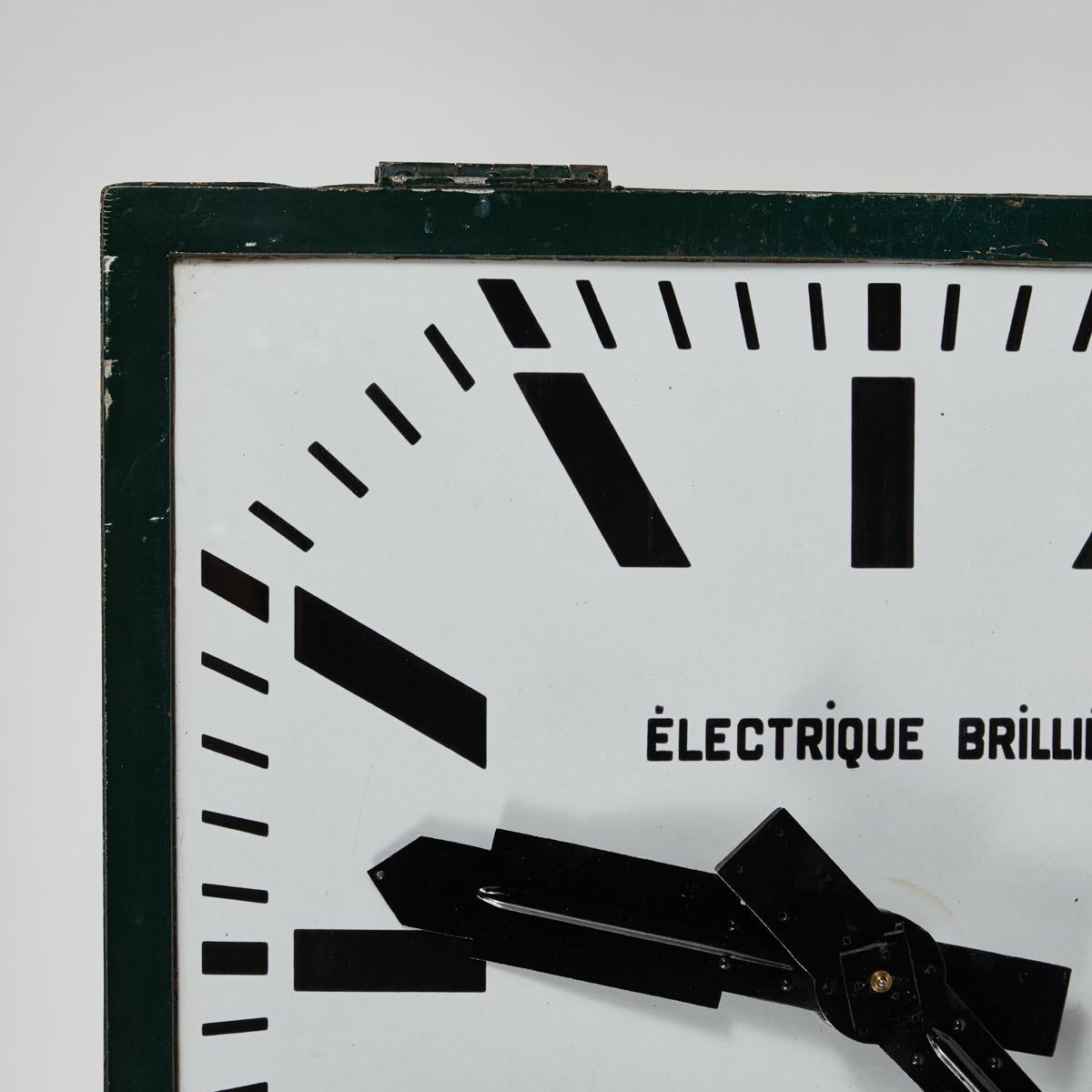 Decorative French turn-of-the-century industrial green metal clock manufactured and designed by renowned clock-smith Électrique Brillé. Featuring with a white and black enameled clock-face with graphic typeface lettering. The bold yet minimalist