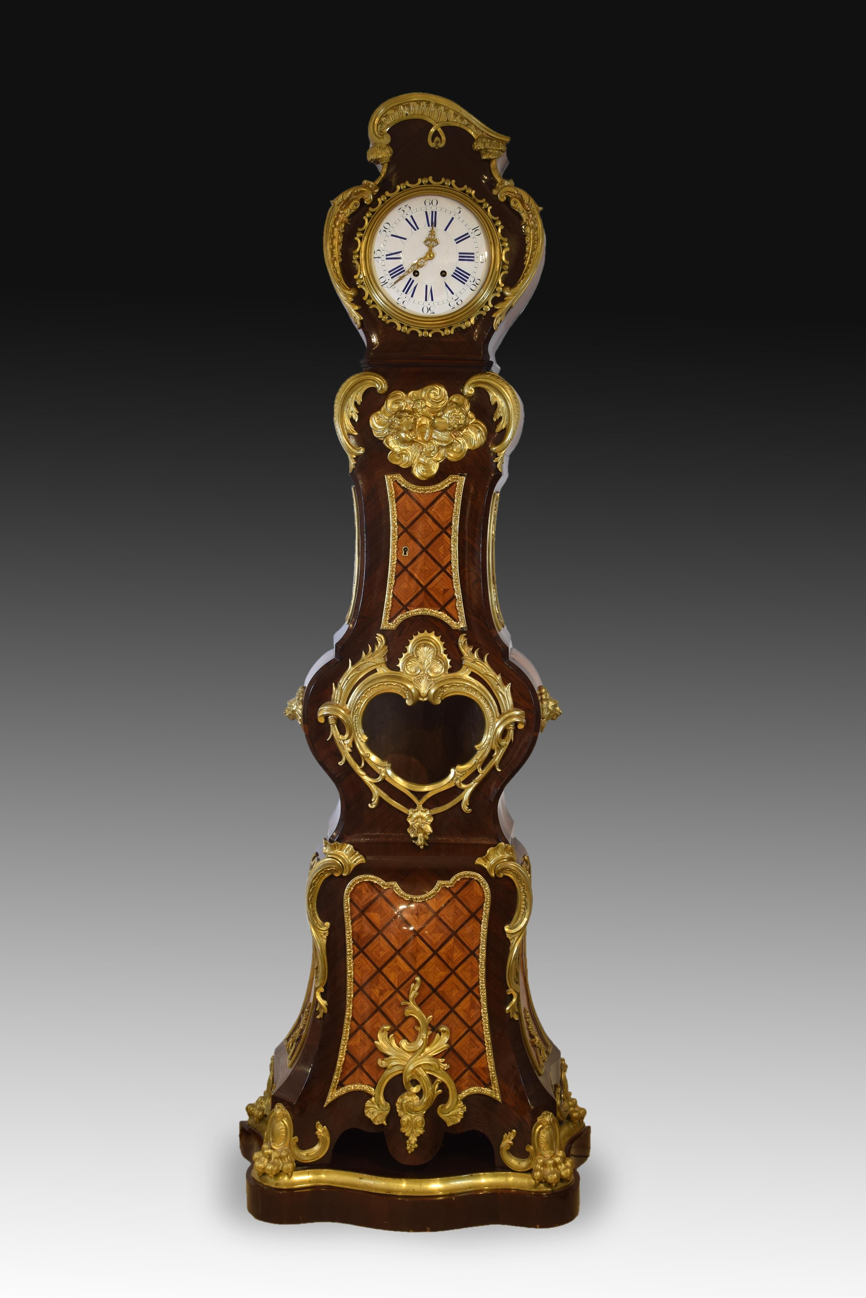 Clock. Palo santo, rosewood, golden bronze. France, 19th century, modeled after Charles Cressent (France, 1685-1768). 
 Wooden box grandfather clock in which palo santo, rosewood and others are combined, enhanced with a series of gilt bronze