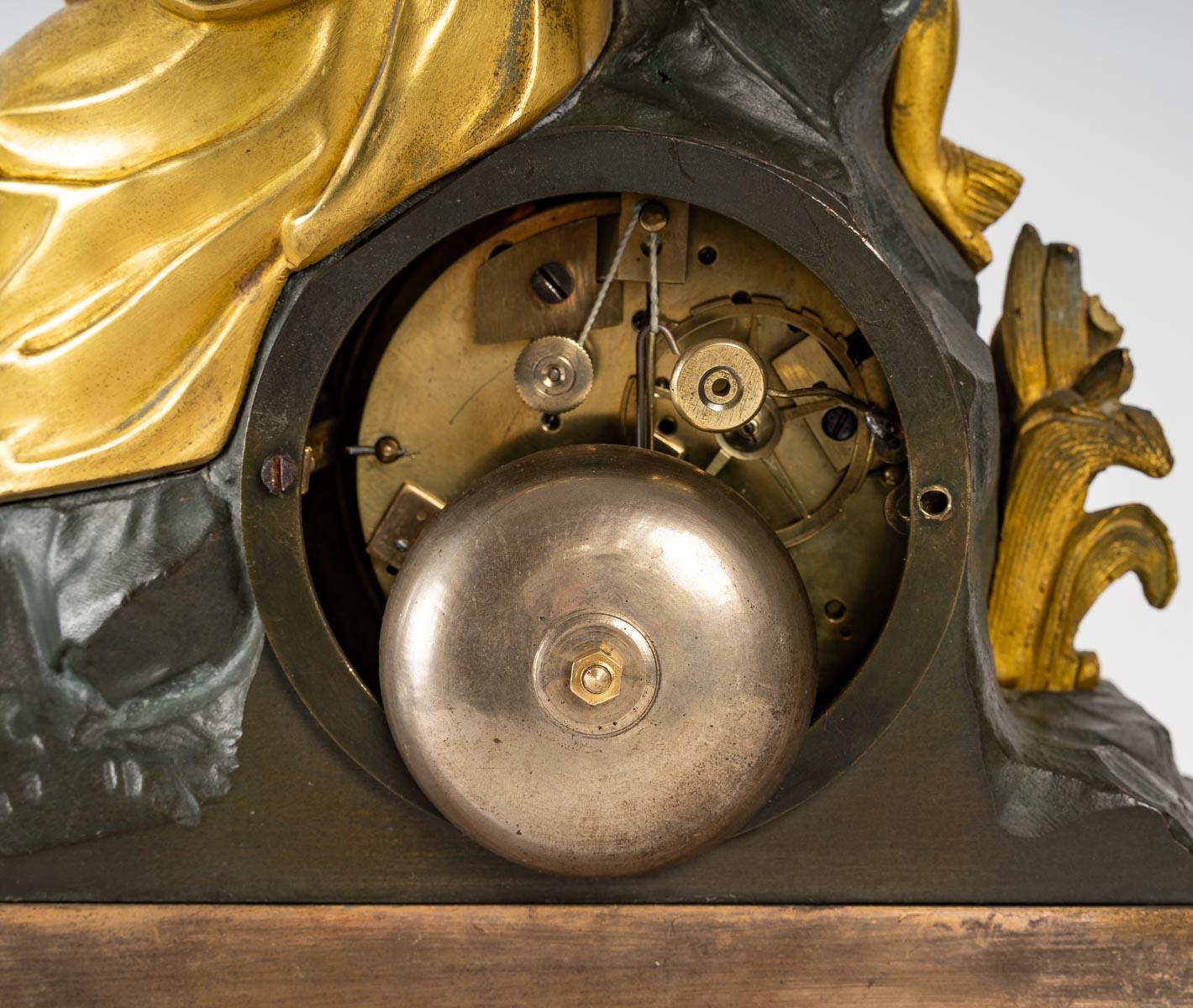 Horloge en bronze doré et patiné, période Napoléon III, XIXe siècle.
en bon état de fonctionnement
Mesures : H : 38 cm, L : 28 cm, P : 8 cm.