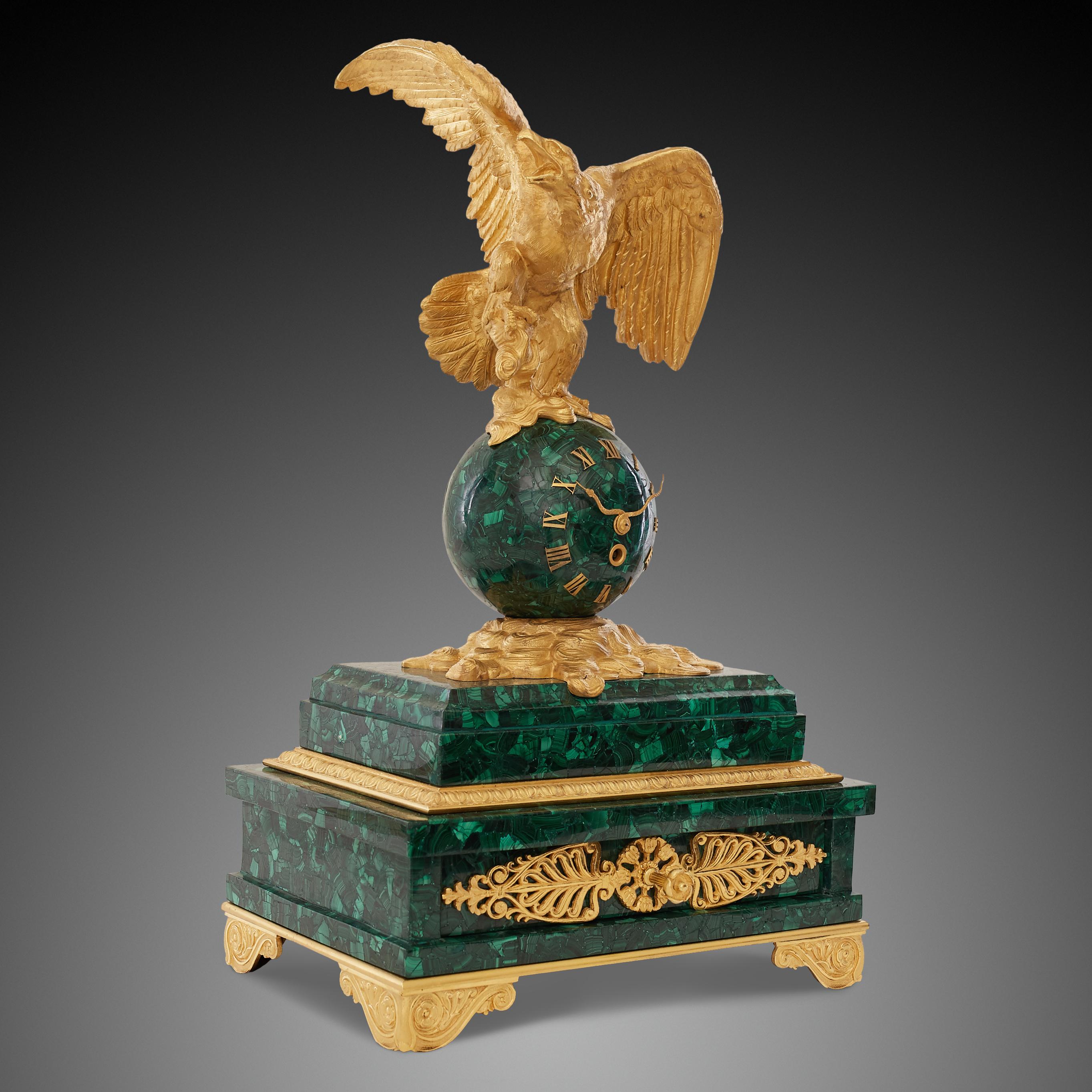 Patriotic French 19th century ormolu bronze eagle standing on a globe malachite mantel clock. The eagle is a symbol of power as well as a recognizable sign of the Empire style. The design of the Empire period was often characterized by militaristic